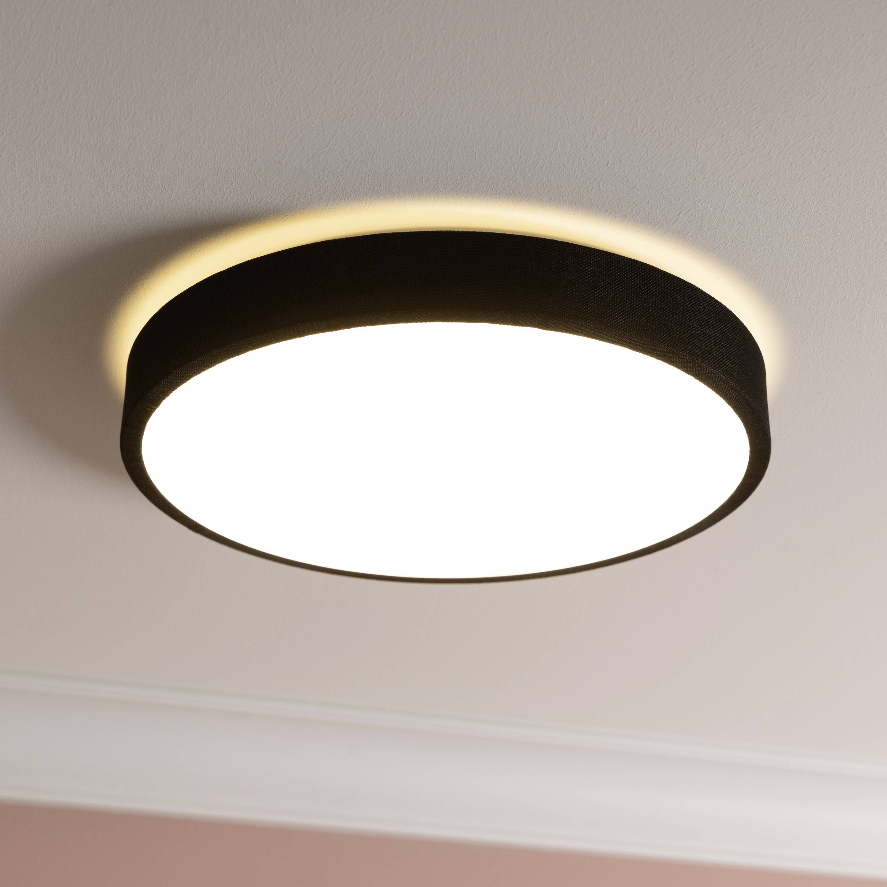 An der Decke befestigte runde Lampe leuchtet hell und gleichmäßig, sorgt für sanfte Raumbeleuchtung.