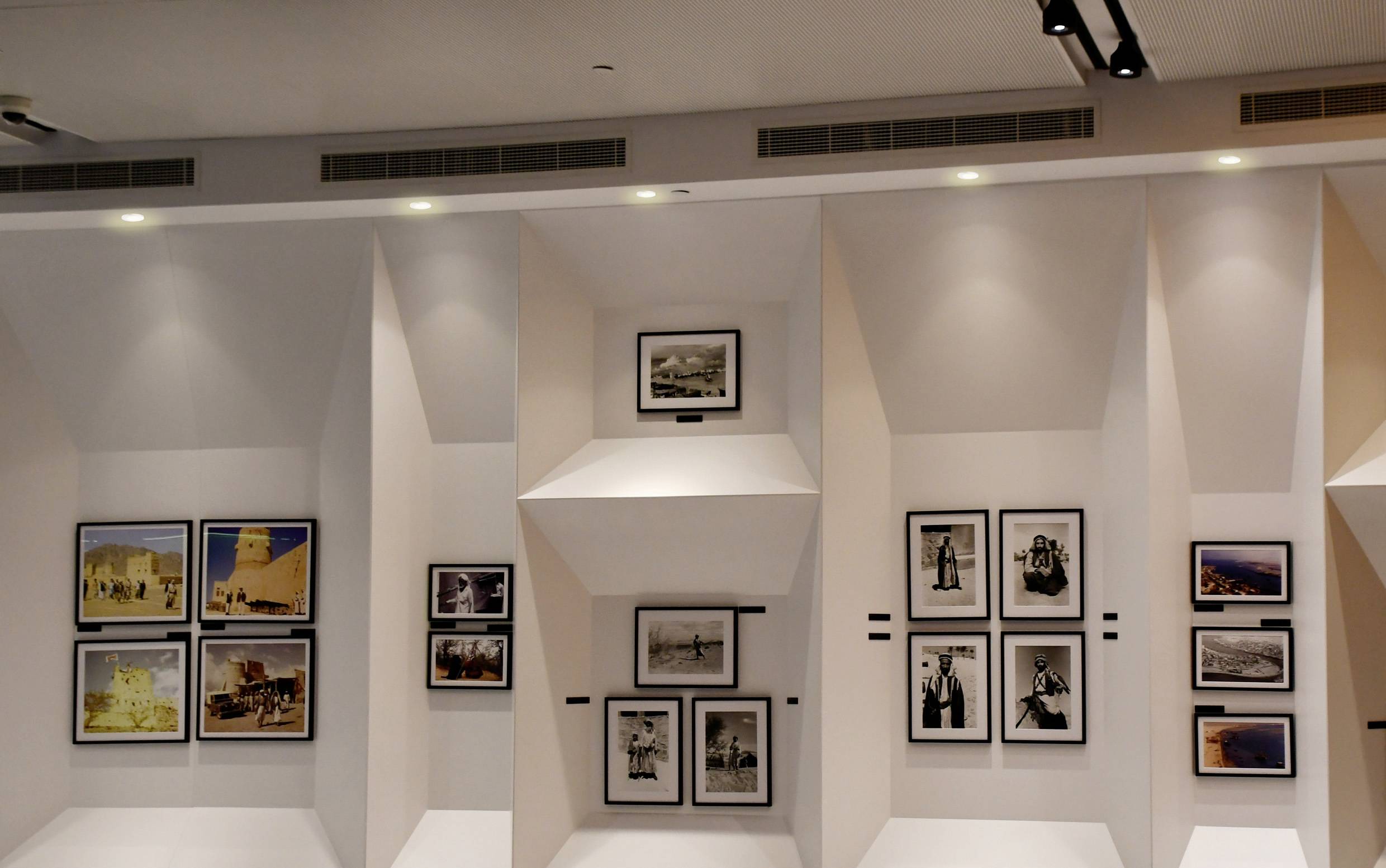 Kunstgalerie-Wand mit gerahmten Fotografien in verschiedenen Größen in einem modernen, hell beleuchteten Ambiente.