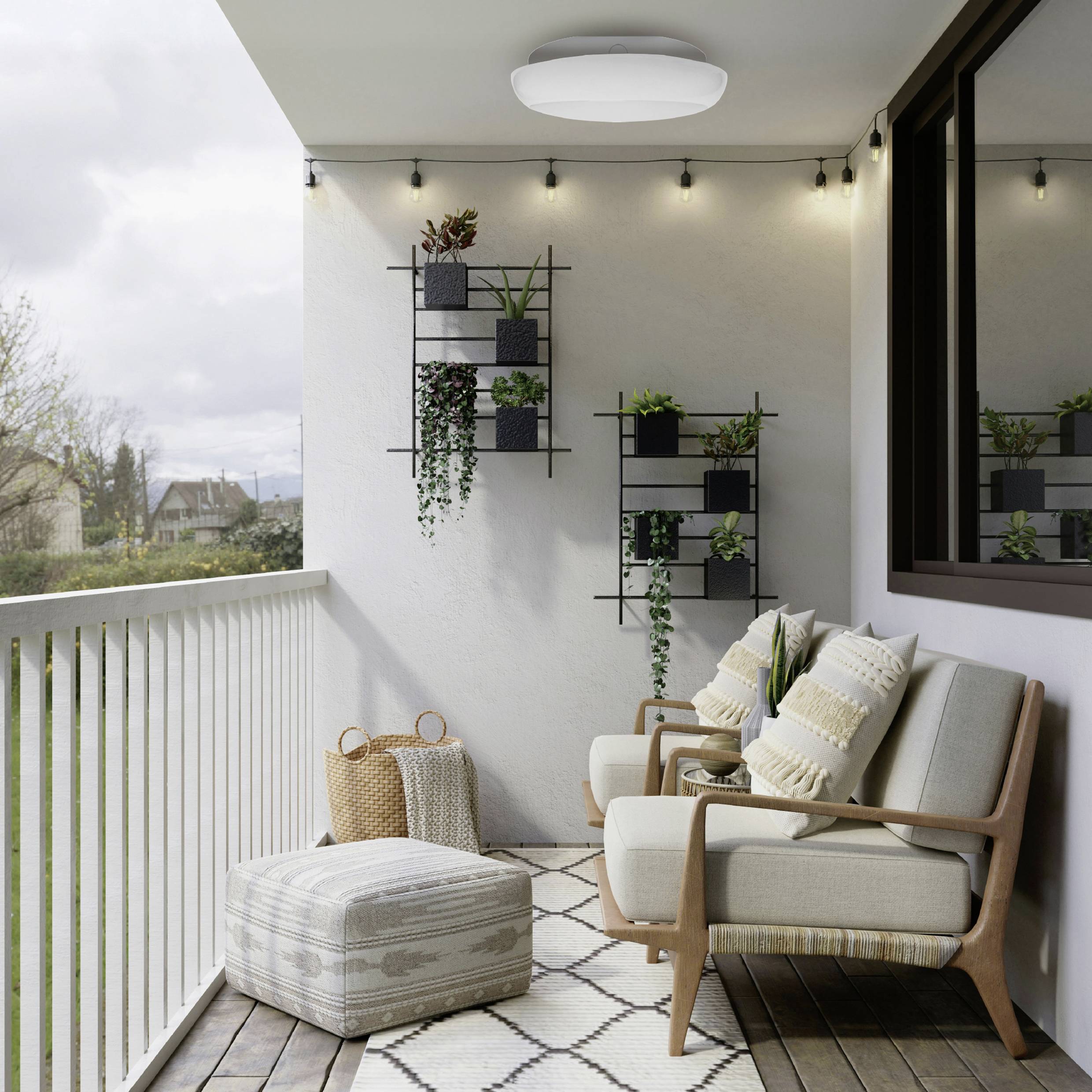Ein gemütlicher Balkon mit Lichterketten, Stühlen und einem Sitzkissen; an der Wand montierte Pflanzen bringen Grün. Eine üppige Landschaft ist im Hintergrund zu sehen.