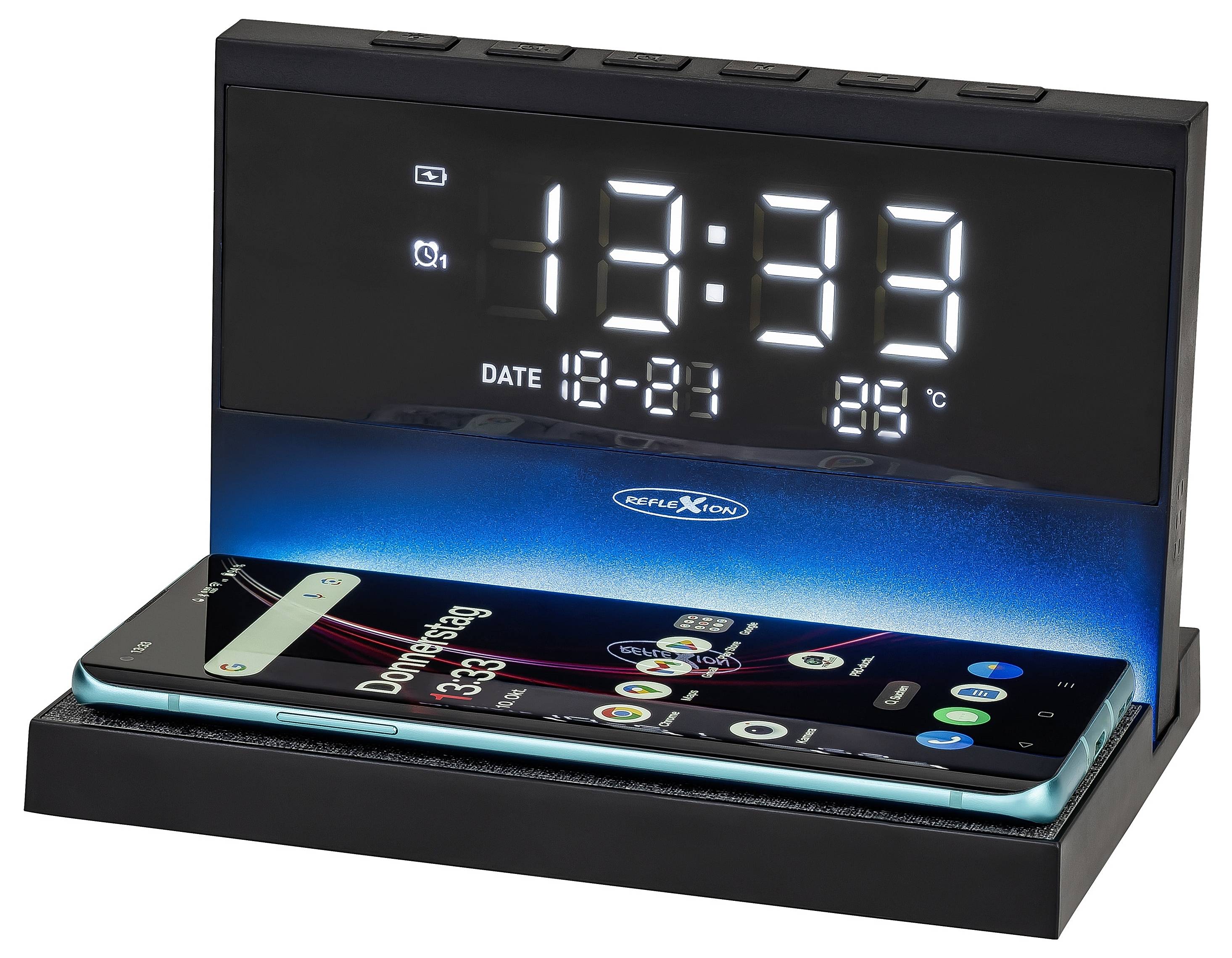 Schwarze digitale Wecker-Dockingstation zeigt 12:33, Datum 18-21 und 88°C an, während sie ein Smartphone auf ihrer Basis lädt.