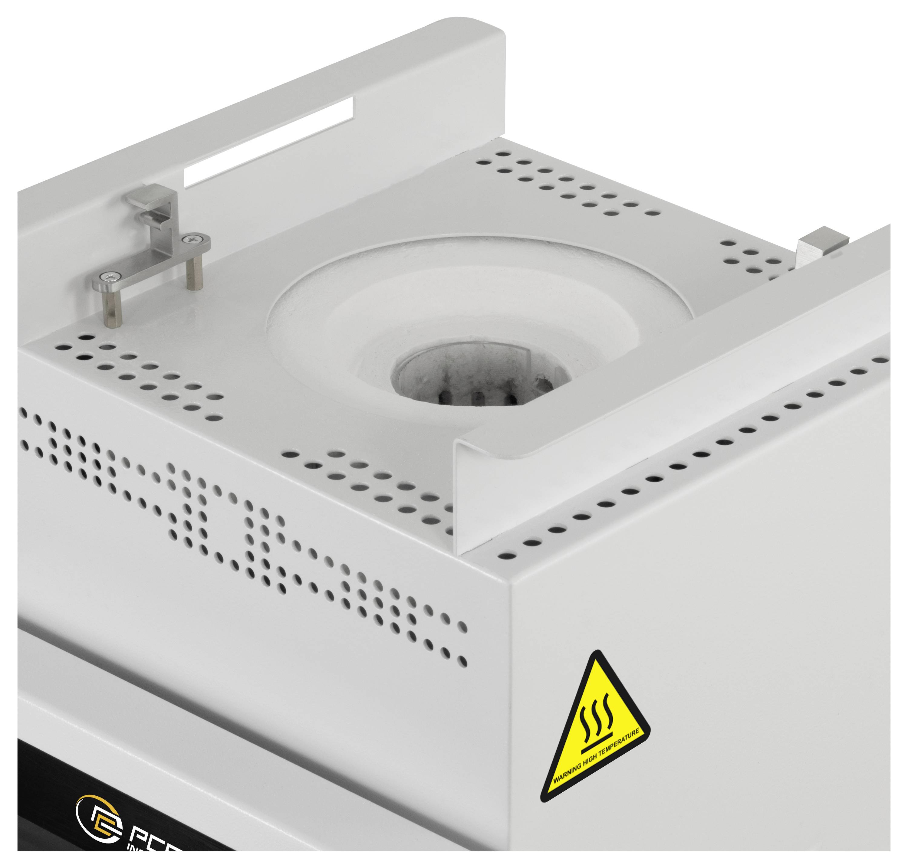 Nahaufnahme einer Laborheizvorrichtung mit einer kreisförmigen Öffnung, perforierter Metalloberseite und gelbem Warnschild für heiße Oberflächen.