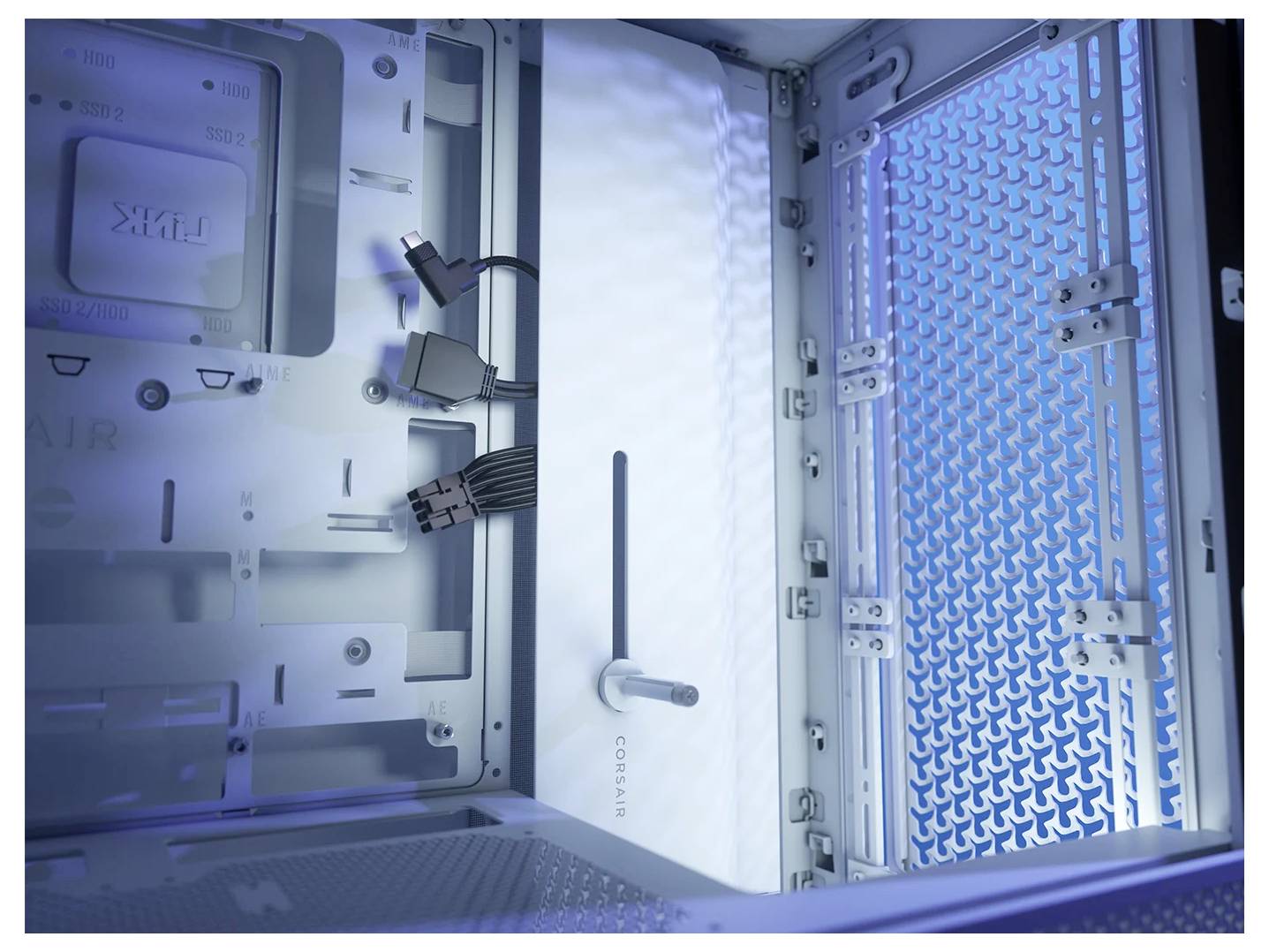 Innenansicht eines blau beleuchteten Computergehäuses ohne installierte Komponenten, zeigt Kabel und Lüftungsgitter.