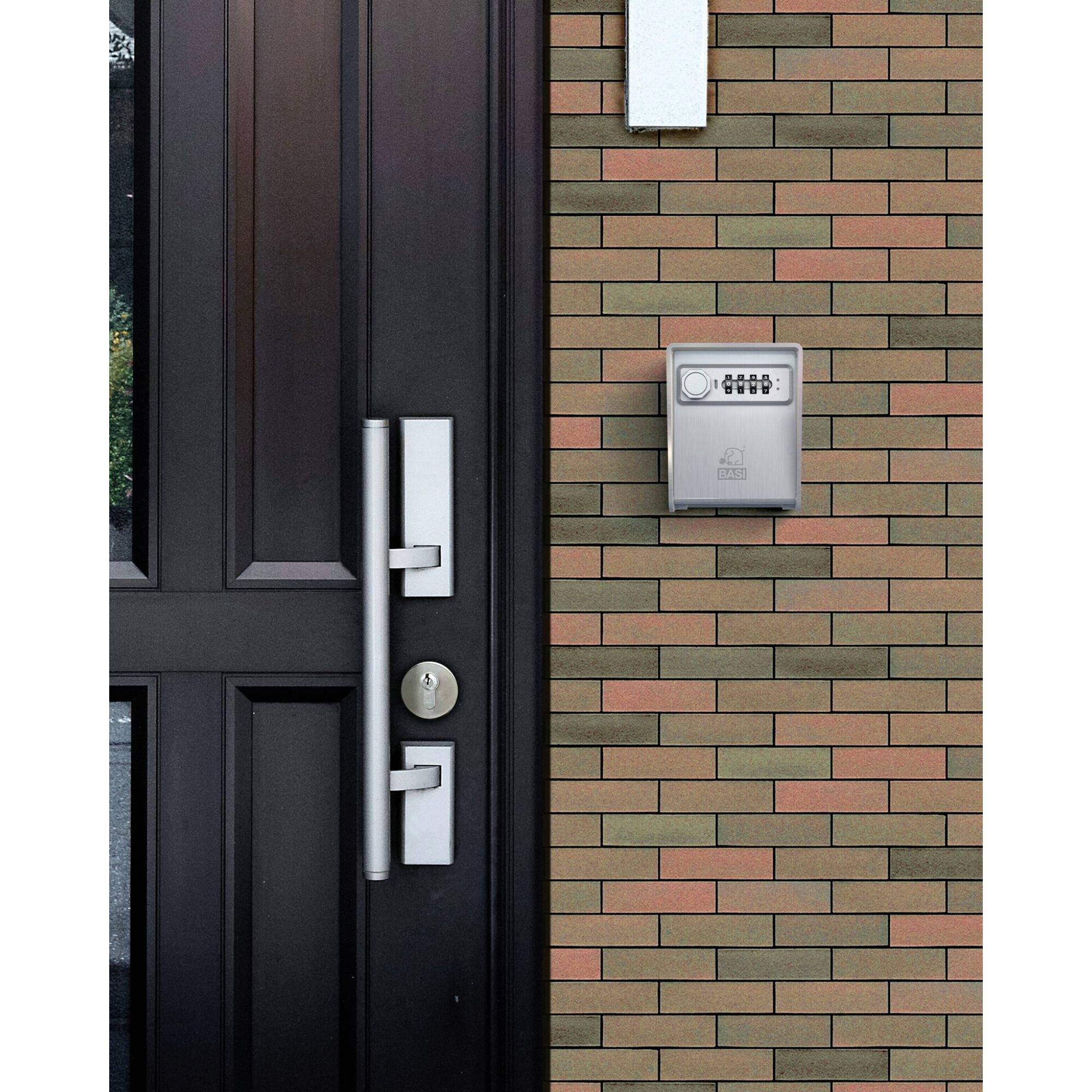 Eine Haustür mit modernem silbernem Griff neben einem kleinen, an der Ziegelwand montierten Briefkasten.