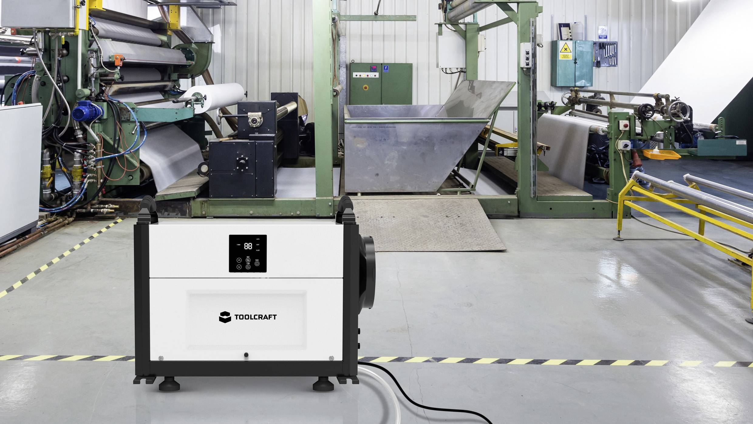 Ein industrieller Raum mit Maschinen zur Papierverarbeitung. Im Vordergrund steht ein Generator mit der Aufschrift 'Toolcraft'.