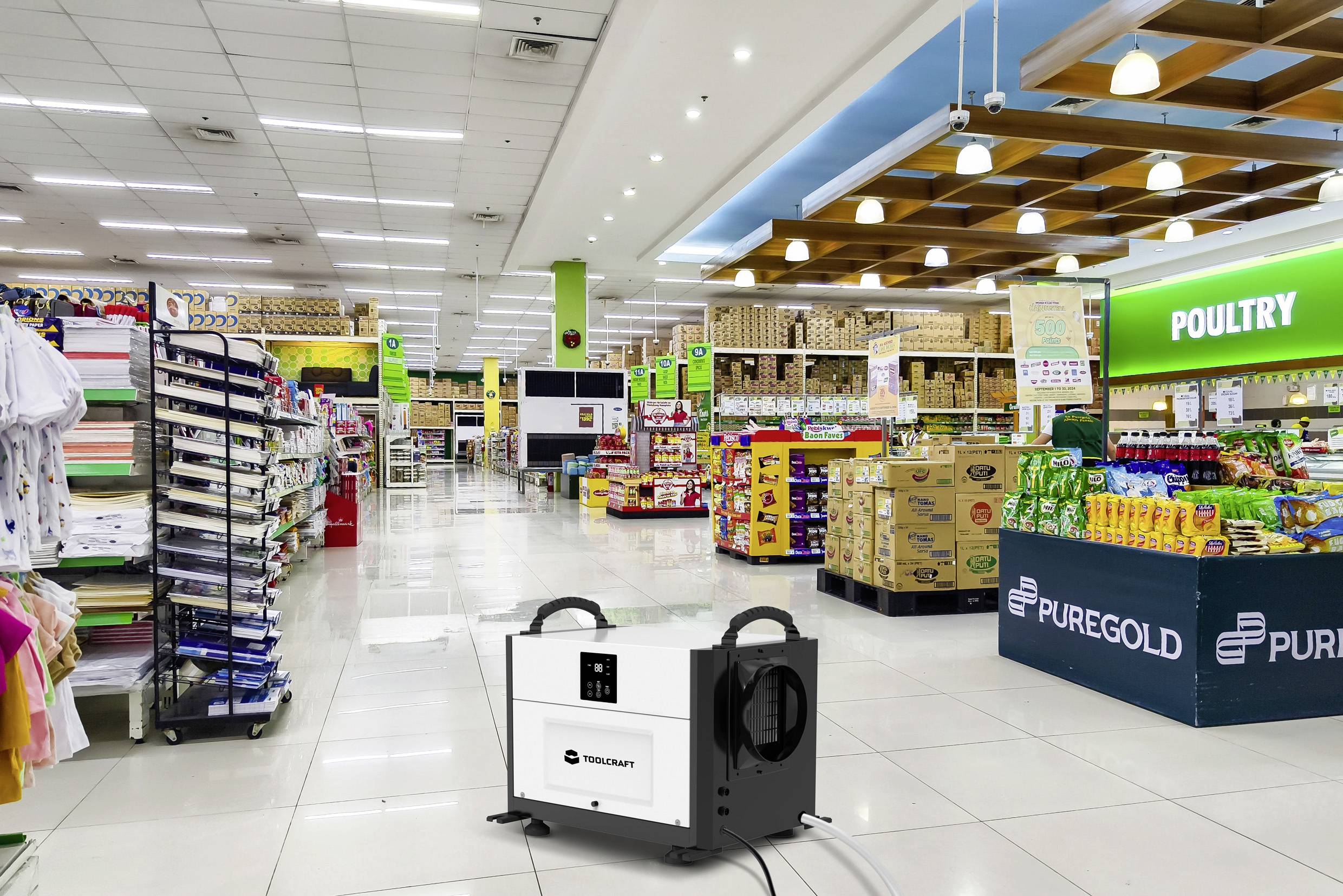 Ein Supermarkt mit breiten Gängen und gut gefüllten Regalen. Im Vordergrund steht ein Gerät, das anscheinend für die Bodenreinigung gedacht ist.