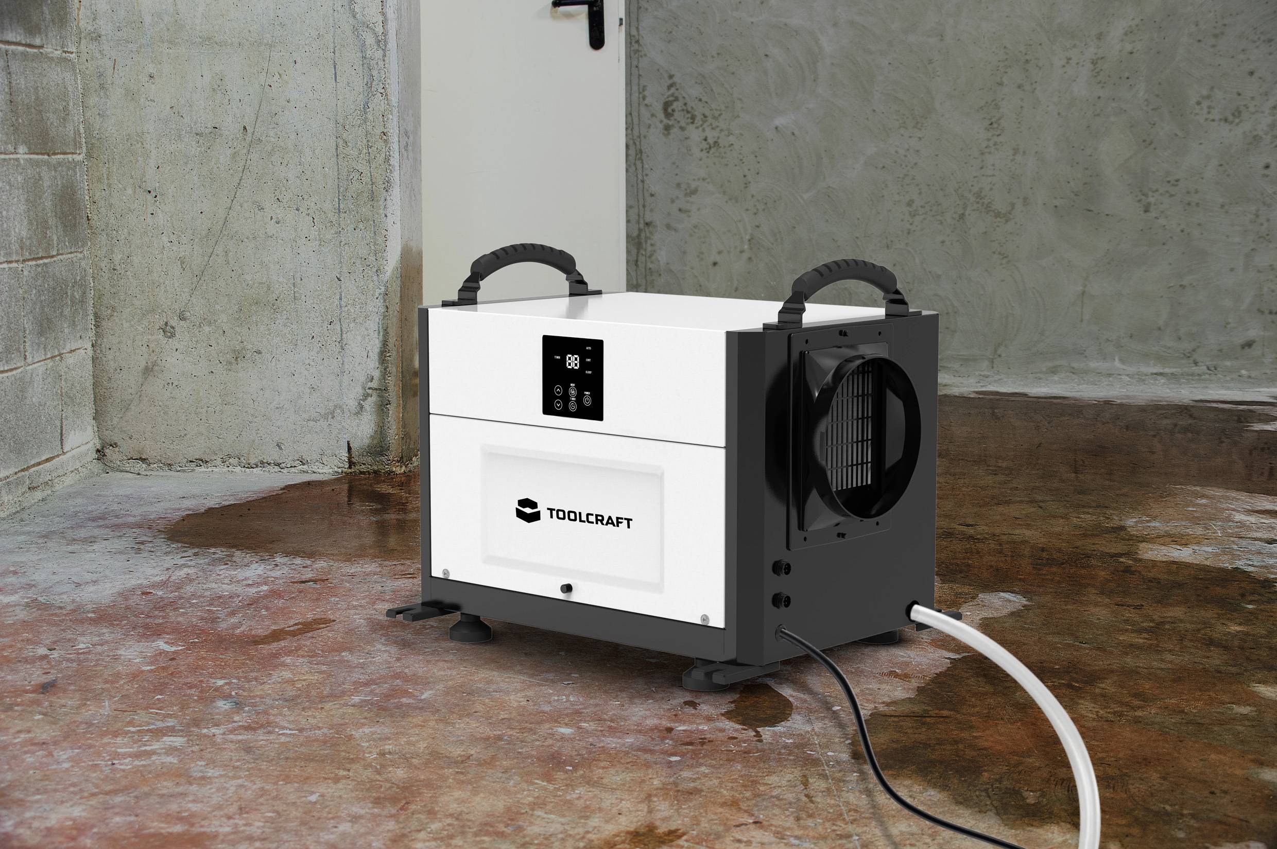 Ein weißer und schwarzer Luftentfeuchter steht auf einem feuchten Betonboden in einem Kellerraum. Ein Kabel führt zu einem Abfluss.