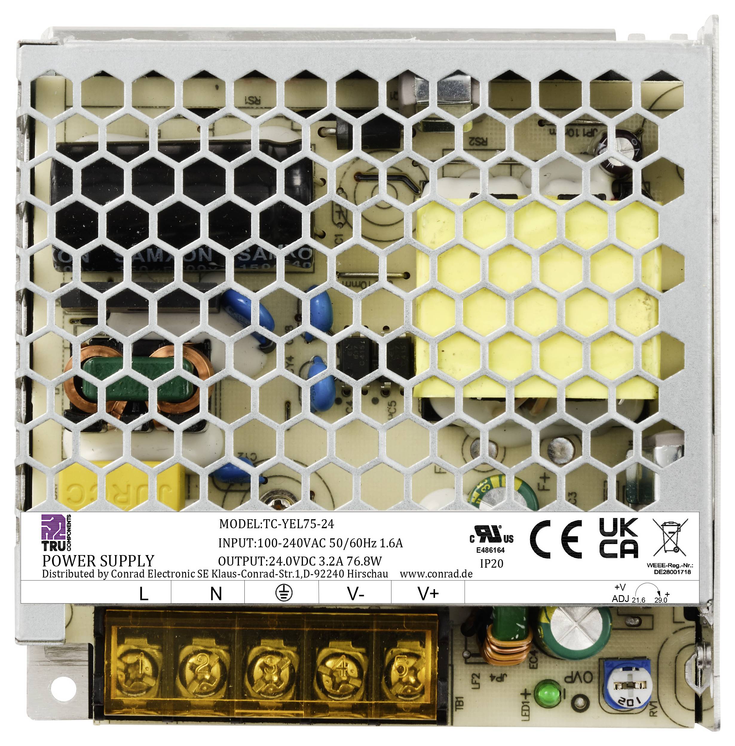 Netzteilgehäuse mit Gitterabdeckung und elektronischen Bauteilen innen; Etikett mit Spezifikationen und Schutzsymbolen sichtbar.