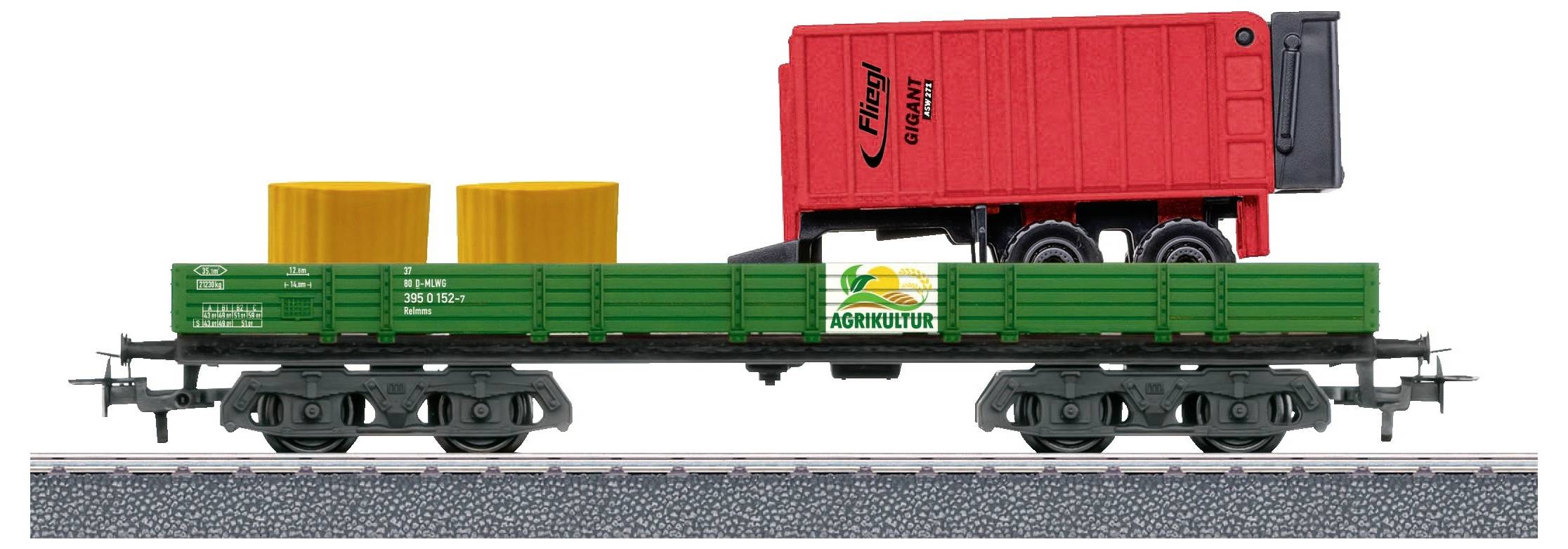 Ein Modellzug mit grünem Güterwagen trägt zwei gelbe Zylinder und einen roten Container. Der Container ist als Anhänger gestaltet.