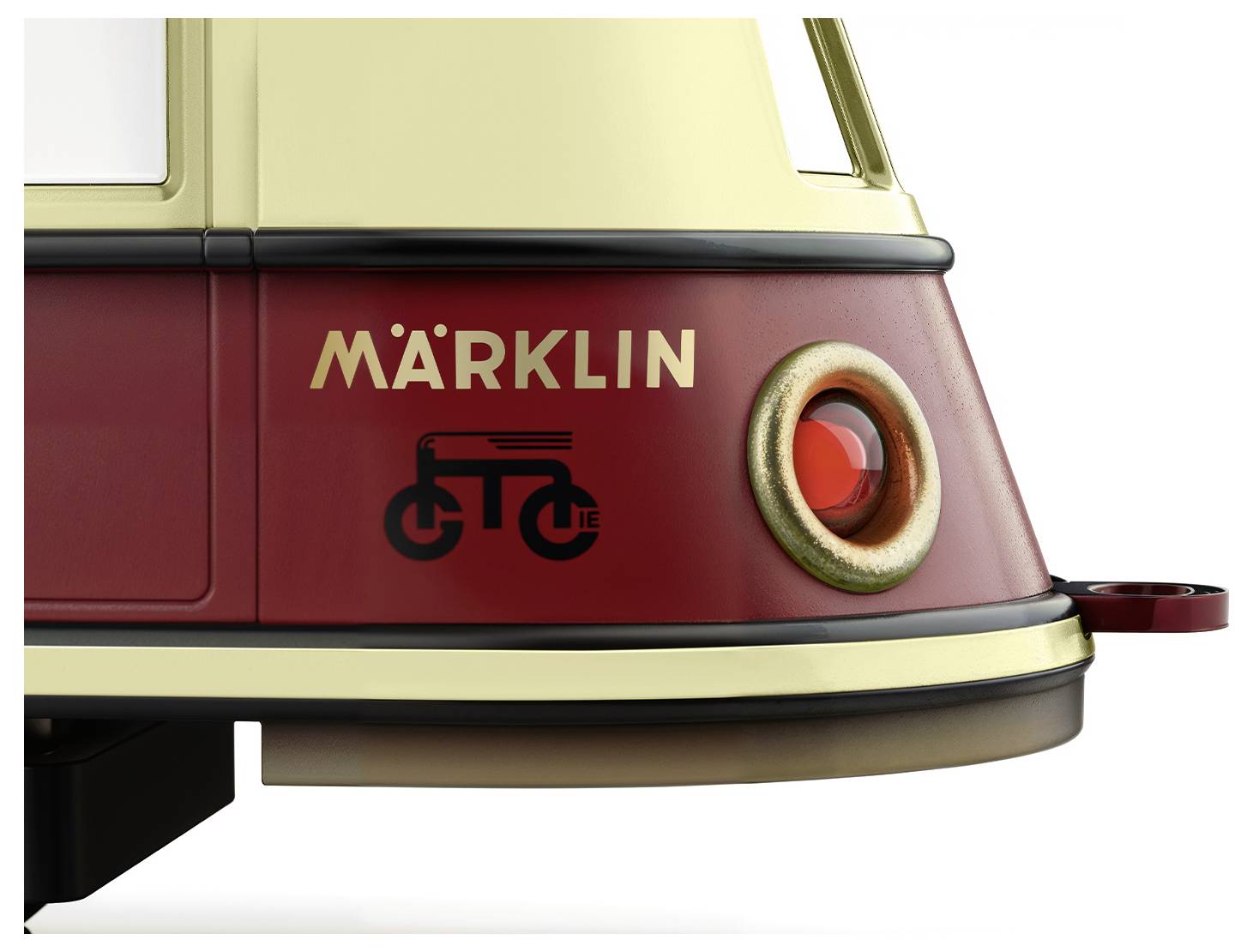 Nahaufnahme eines rot-gelben Modells eines Märklin-Zuges mit stilisiertem Fahrradsymbol und rotem runden Detail an der Seite.