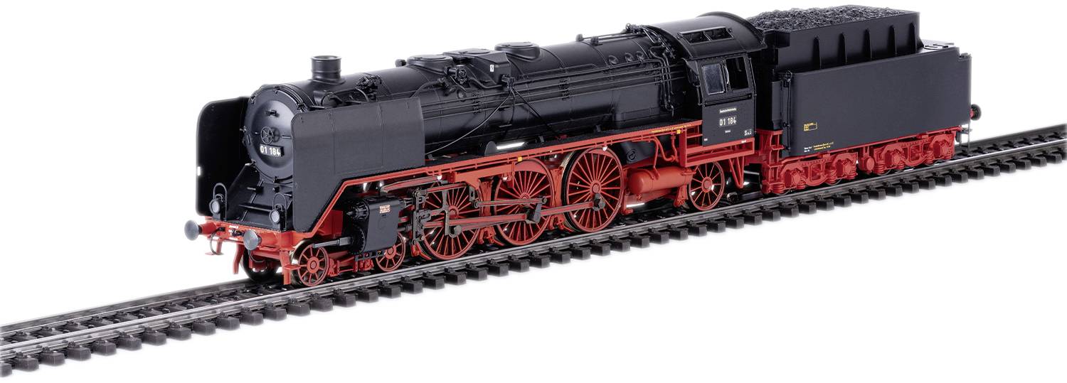 Schwarze Dampflokomotive mit roten Rädern auf einem Gleis. Sie hat einen markanten Schornstein und ist detailreich nachgebildet.