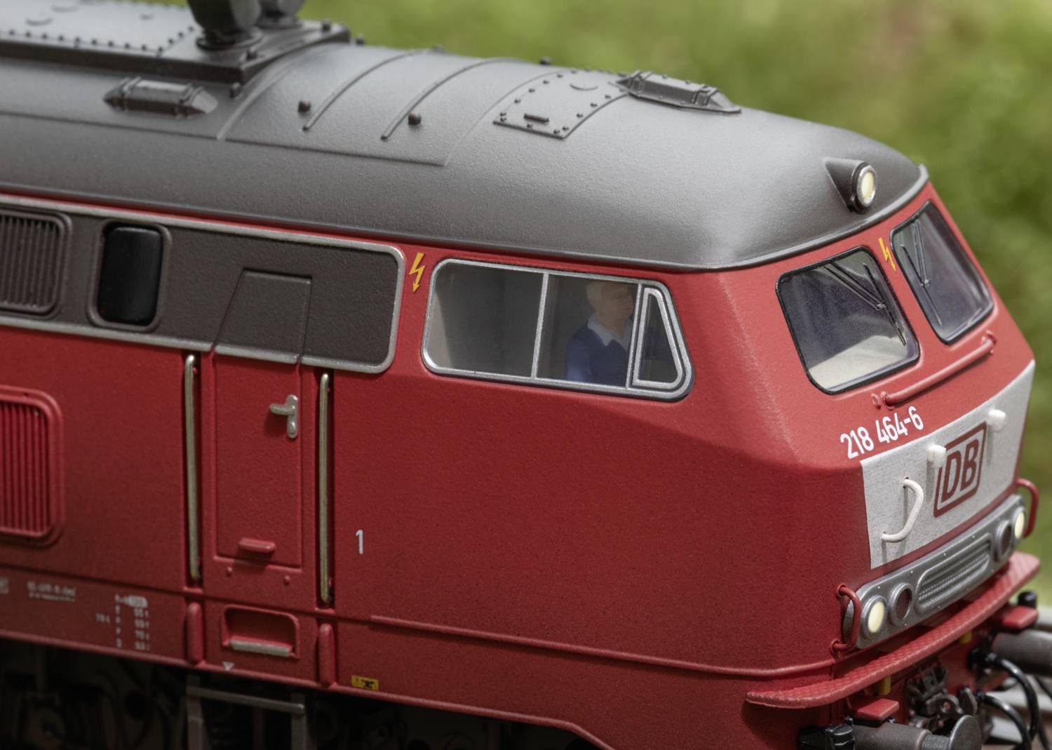 Eine rote Lokomotive der Deutschen Bahn, seitliche Nahaufnahme des Führerhauses, mit deutlichen Details der Fenster und Strukturen.