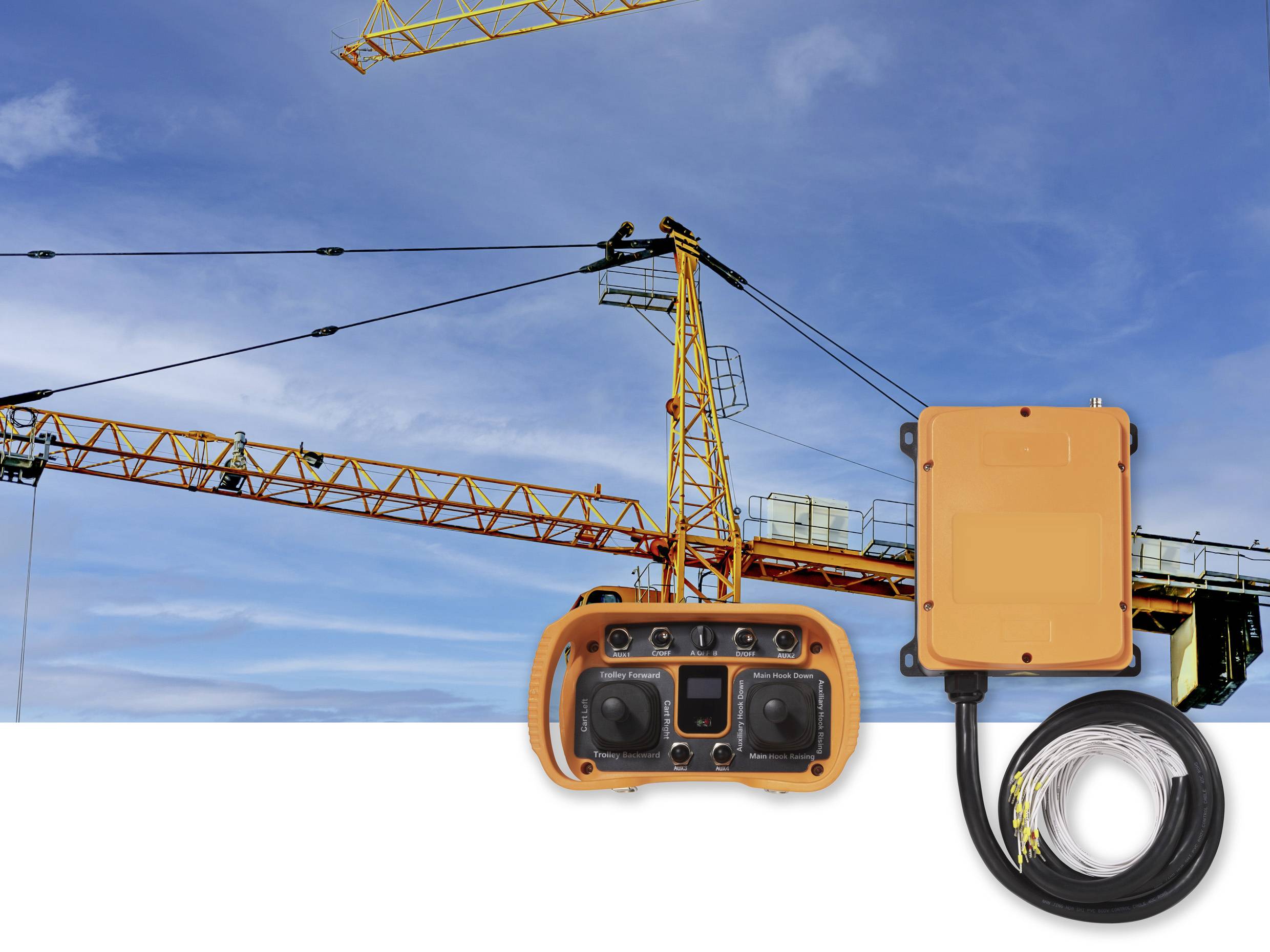 Ein Baukran vor blauem Himmel. Im Vordergrund liegen eine orange Fernbedienung und deren Kabel, die den Kran steuern können.
