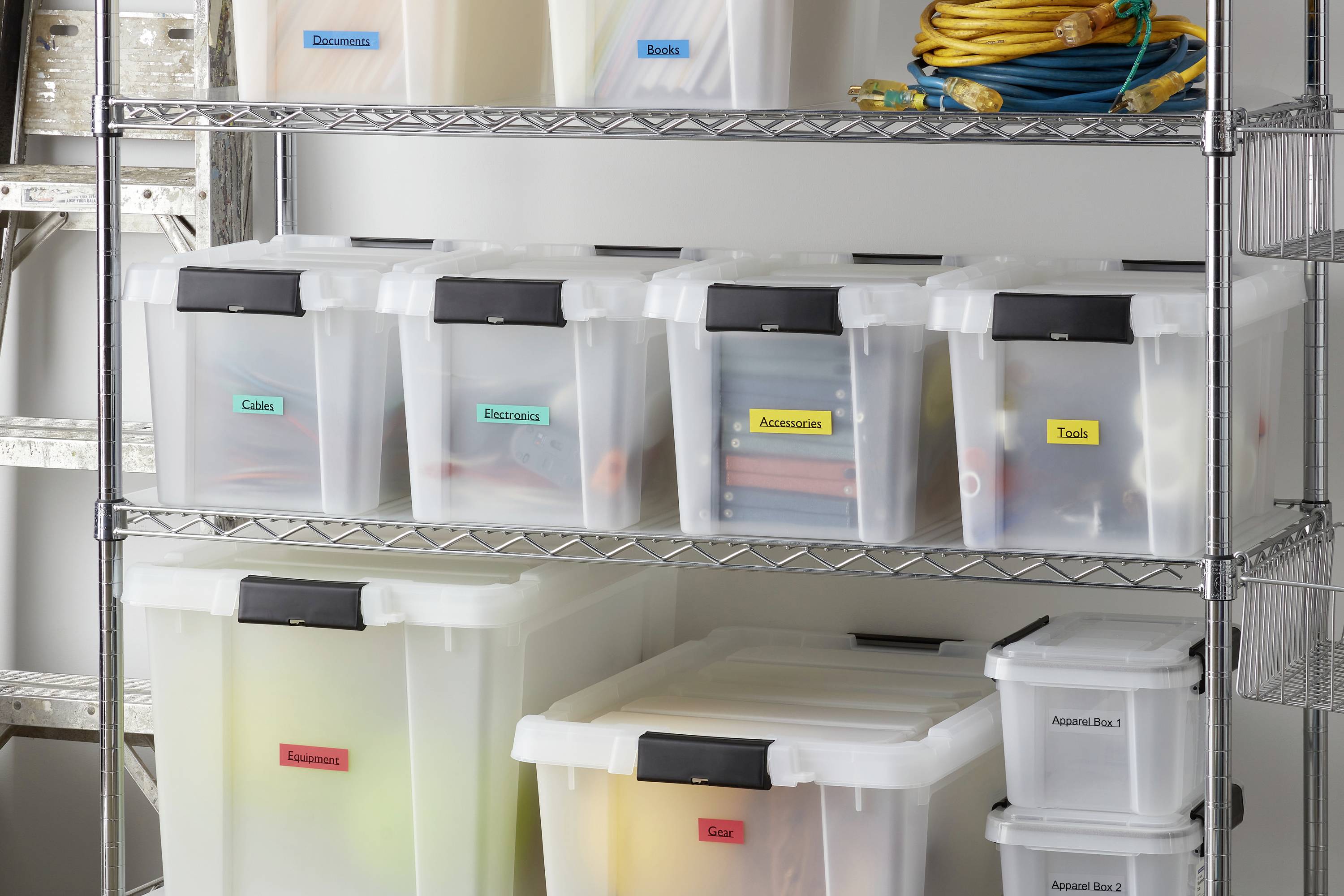 Regale aus Metall mit durchsichtigen Plastikboxen beschriftet mit 'Kabel', 'Elektronik', 'Werkzeuge' und mehr für organisierte Lagerung.