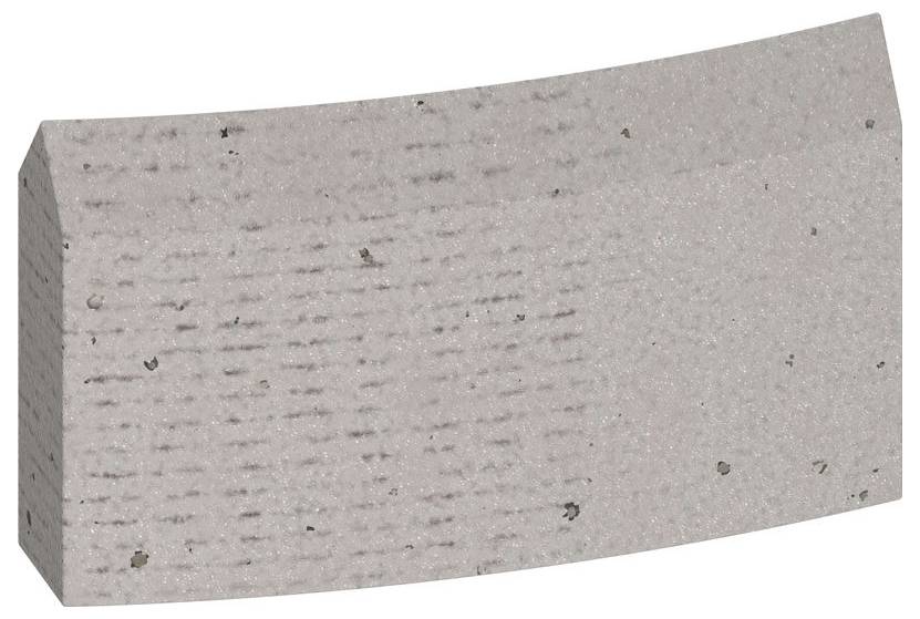 Ein rechteckiger, leicht gebogener Ziegelstein in Grau mit einer texturierten Oberfläche.