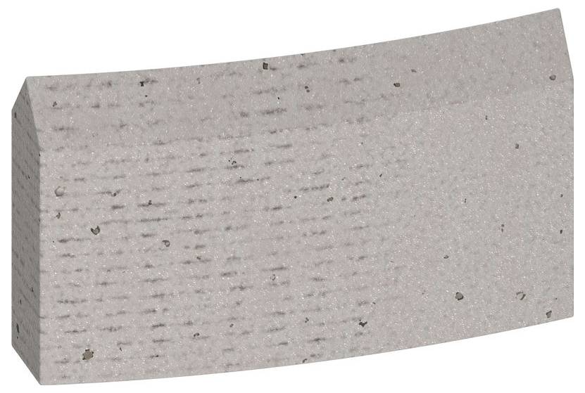 Ein grauer, gekrümmter Betonstein mit glatter Oberfläche und kleinen Einsprengseln. Geeignet für Bau- und Pflasterprojekte.