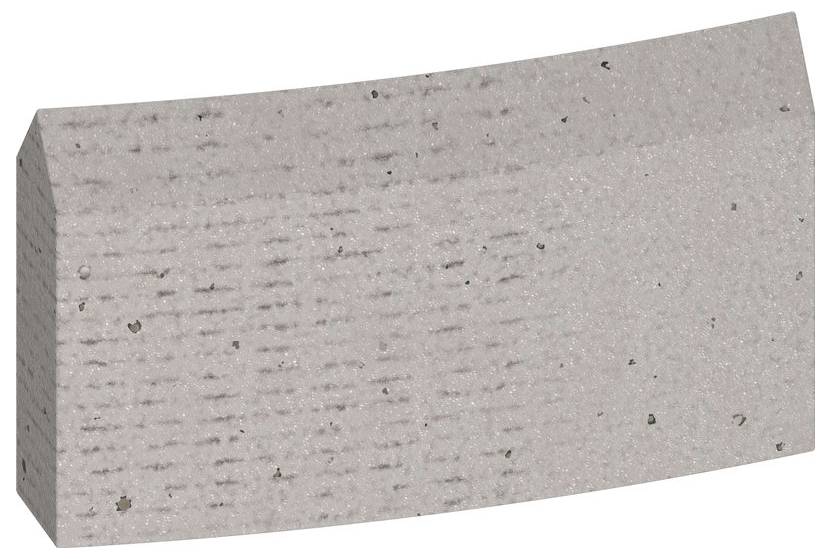 Ein graubrauner Ziegelstein mit rechteckiger Form und leicht gebogener Oberfläche. Oberfläche zeigt leichte Textur und kleine Flecken.