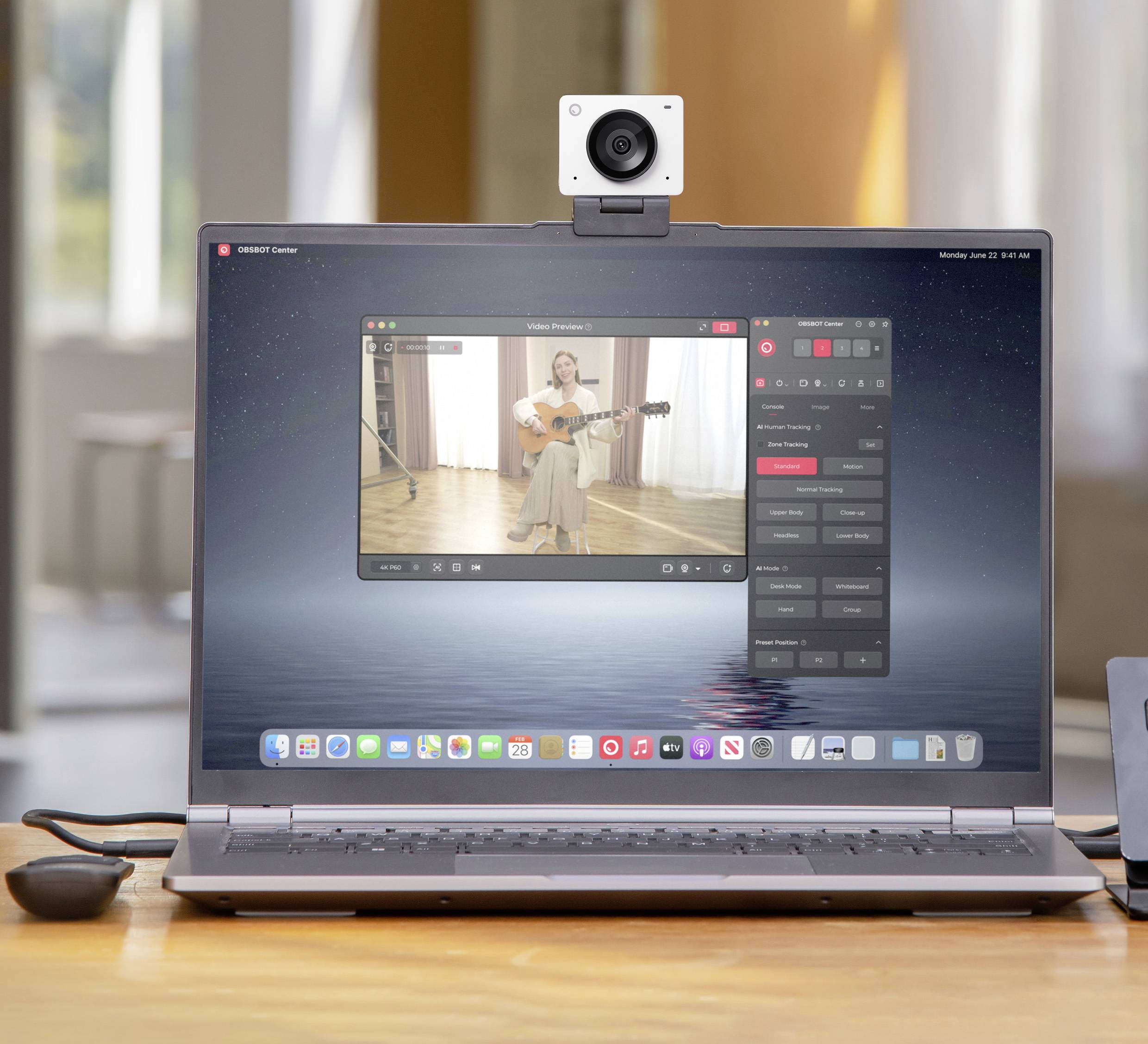 Ein Laptop zeigt eine Videoaufnahme einer Person, die Gitarre spielt. Über der Webcam ist eine Kamera angebracht.