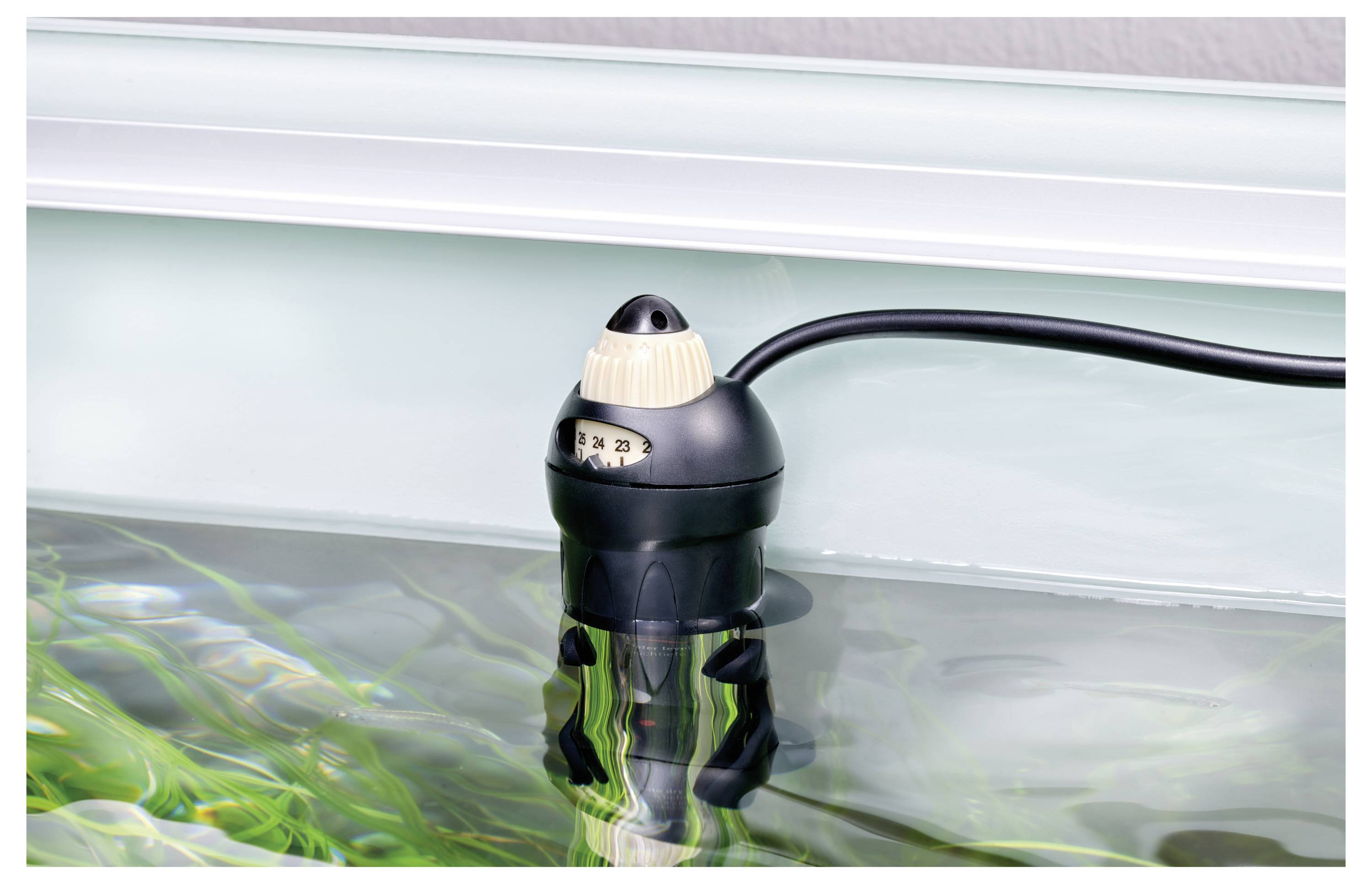 Ein Aquariumheizer, der teilweise in Wasser eingetaucht ist, mit einem sichtbaren Thermostatregler, der Temperatureinstellungen anzeigt.