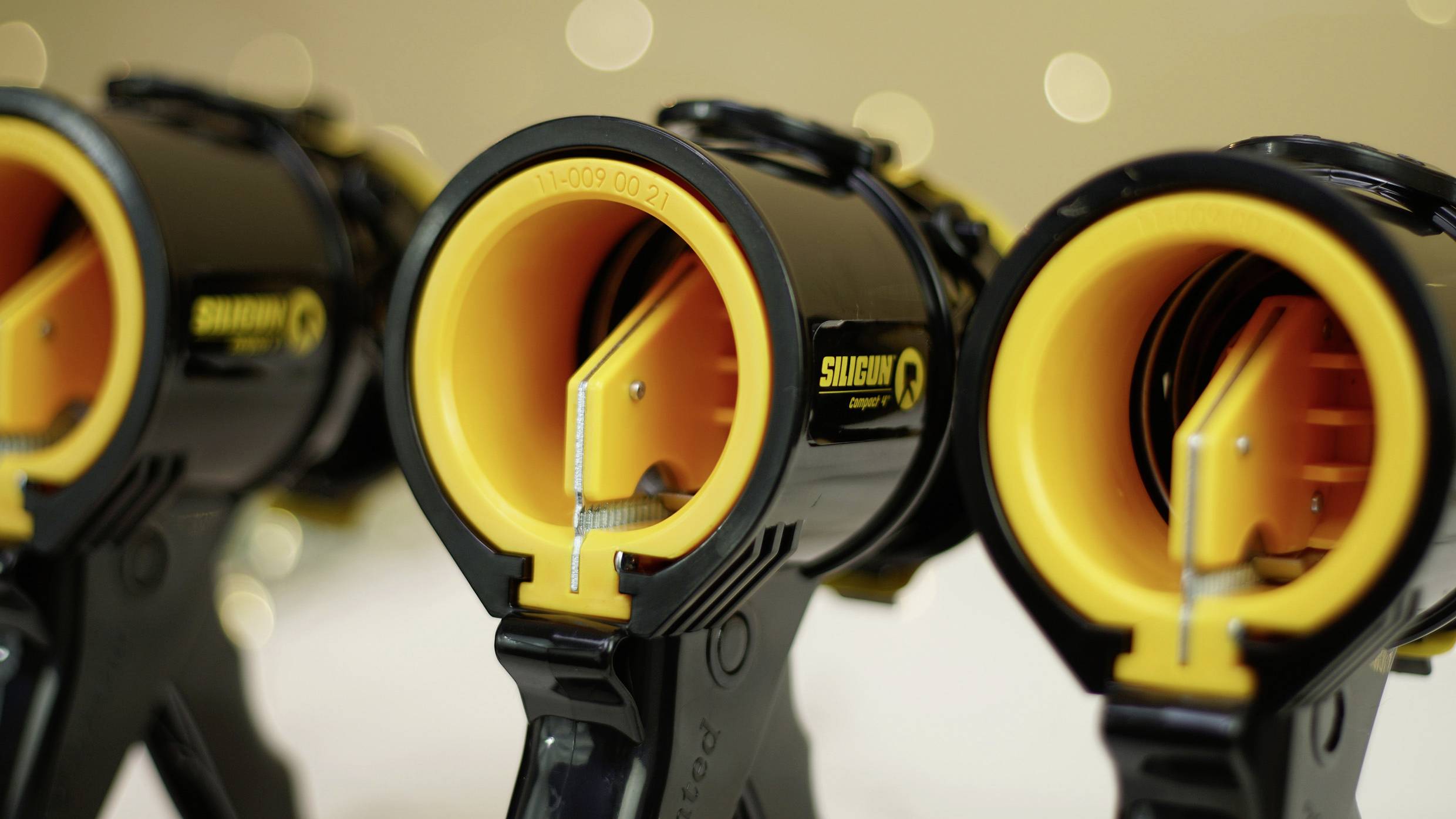 'Drei gelbe Klebebandspender in Nahaufnahme, mit schwarzem Gehäuse und dem Schriftzug 