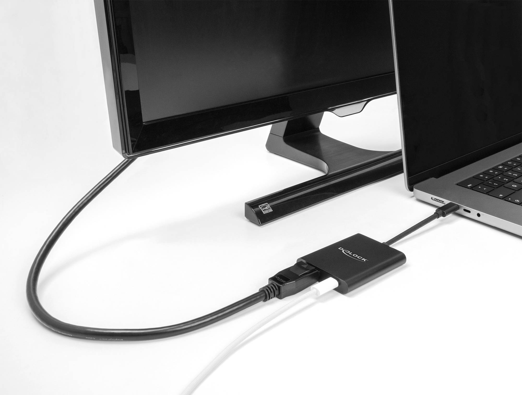 Laptop, verbunden mit einem Monitor durch ein HDMI-Kabel und Adapter, auf einem weißen Hintergrund. Hauptthema: Technikverbindung.