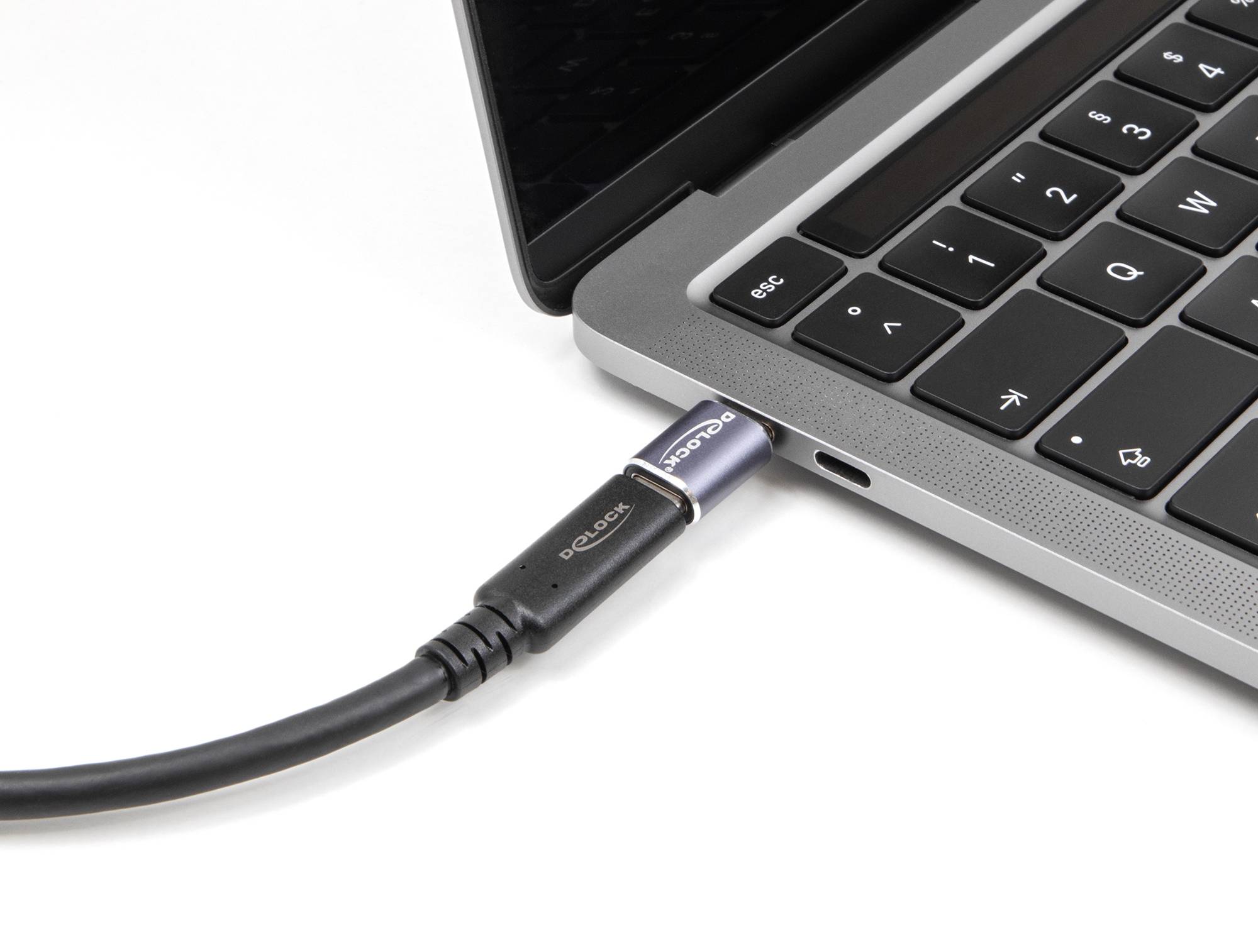 Ein Laptop in Nahaufnahme mit einem eingesteckten USB-Kabel auf der linken Seite, das eine Verbindung zur Stromquelle herstellt.