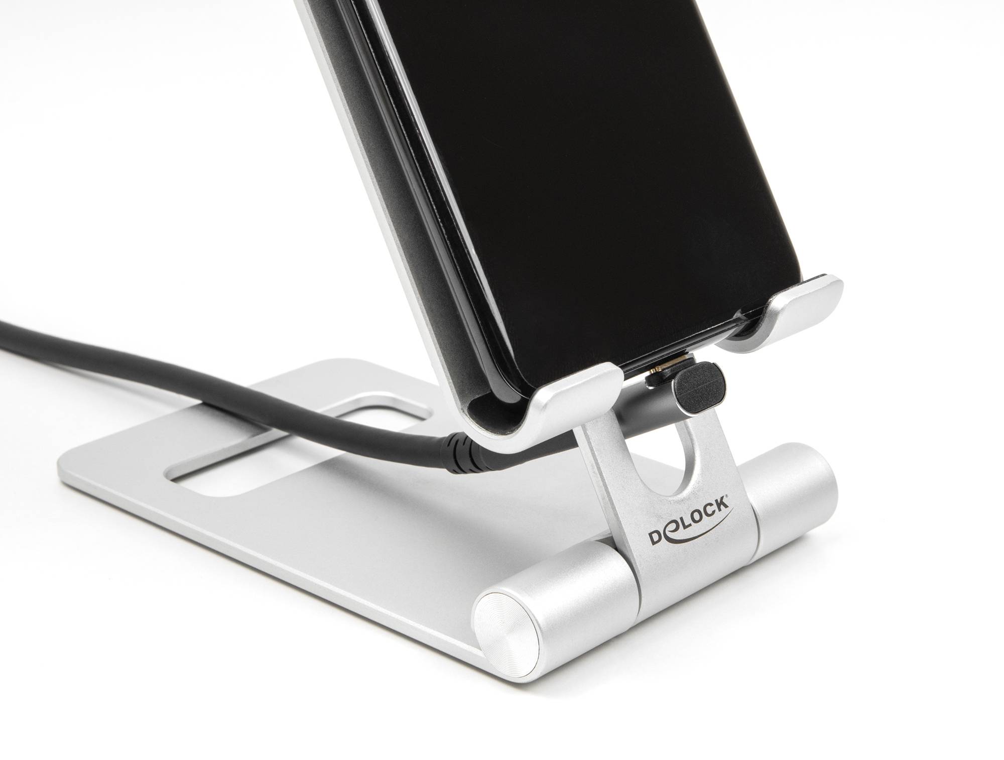 Smartphone in einem silbernen Ständer mit einem angeschlossenen Ladekabel, Markenname 'Delock' auf dem Ständer sichtbar.
