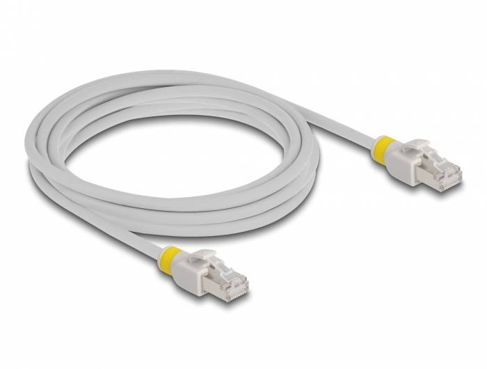 Ein graues Ethernet-Kabel mit gelben Markierungen an den Steckern, aufgerollt und auf eine weiße Oberfläche gelegt.