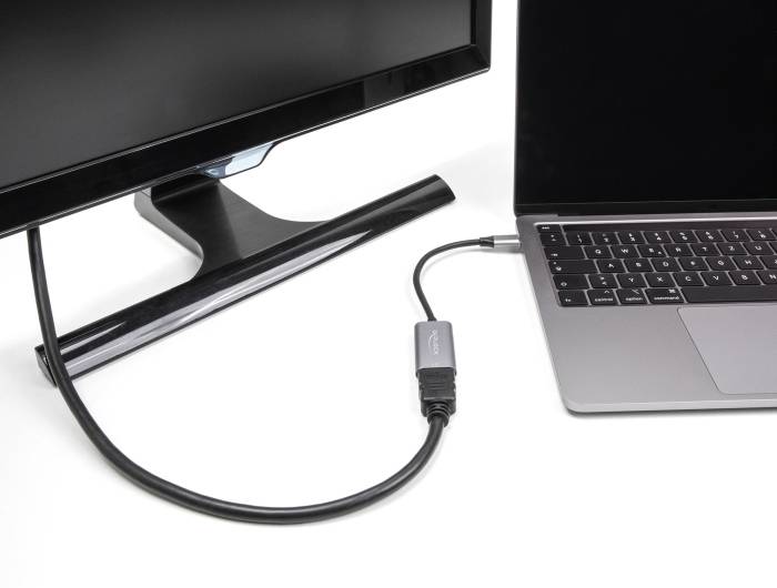 Ein Monitor ist mit einem Laptop verbunden, indem ein Kabel genutzt wird, das vom Bildschirm zur Seite des Laptops führt.