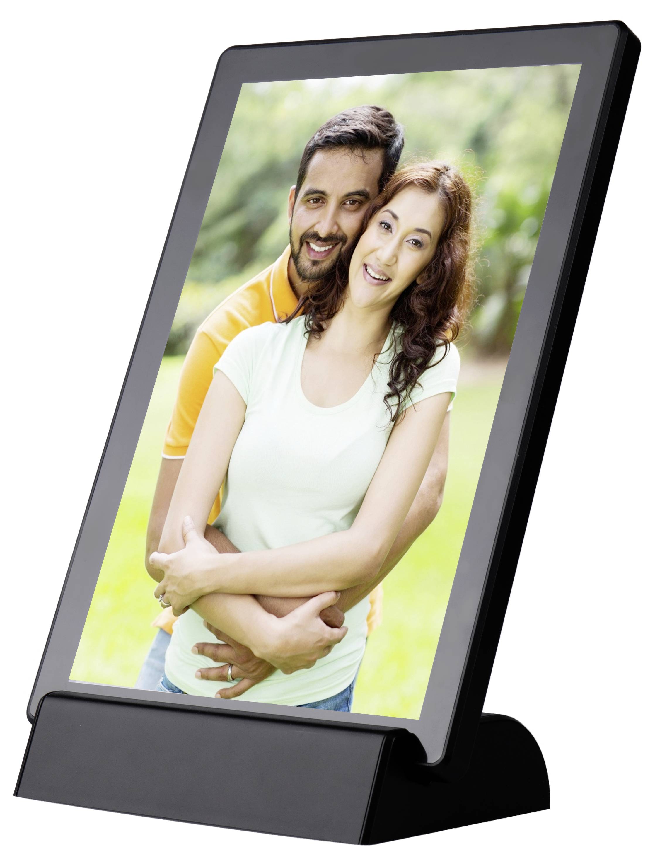 Ein lächelndes Paar steht im Freien. Er umarmt sie von hinten, beide wirken glücklich und entspannt. Hintergrund ist grün und unscharf.