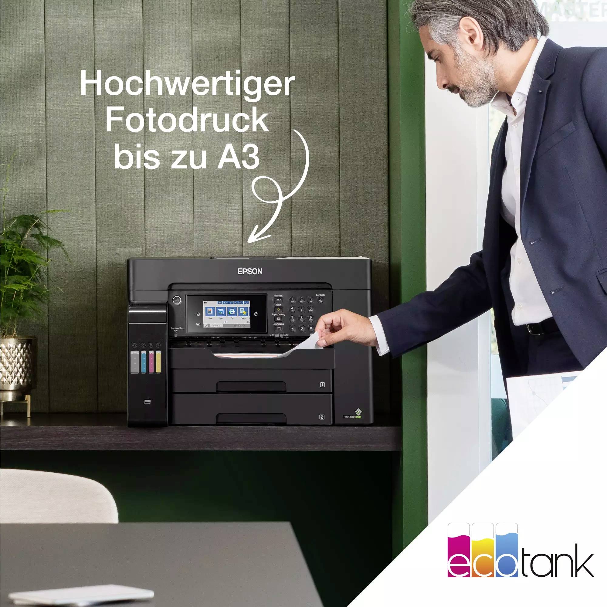 Eine Person bedient einen Epson-Drucker 'Fotodruck bis zu A3'. Der Raum wirkt modern mit Pflanzen und einem Tisch im Vordergrund.