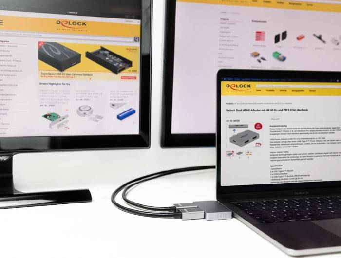 Zwei Monitore und ein Laptop zeigen eine Produktwebseite mit Elektronikartikeln. Kabel verbinden die Geräte miteinander.