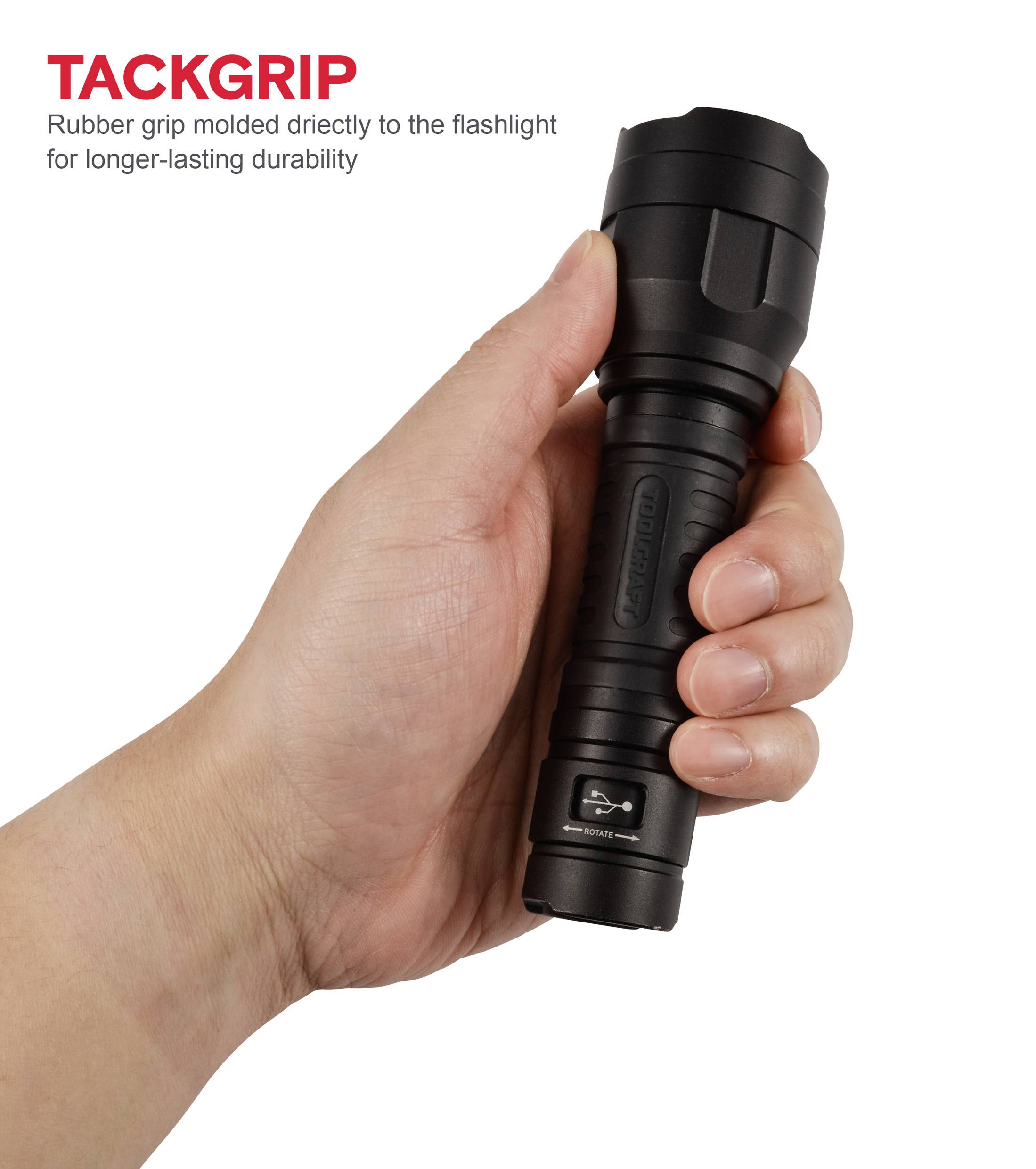 Hand hält eine schwarze Taschenlampe mit gummiertem Griff. Oben links steht 'TACKGRIP' mit Hinweis auf die langlebige Gummibeschichtung.