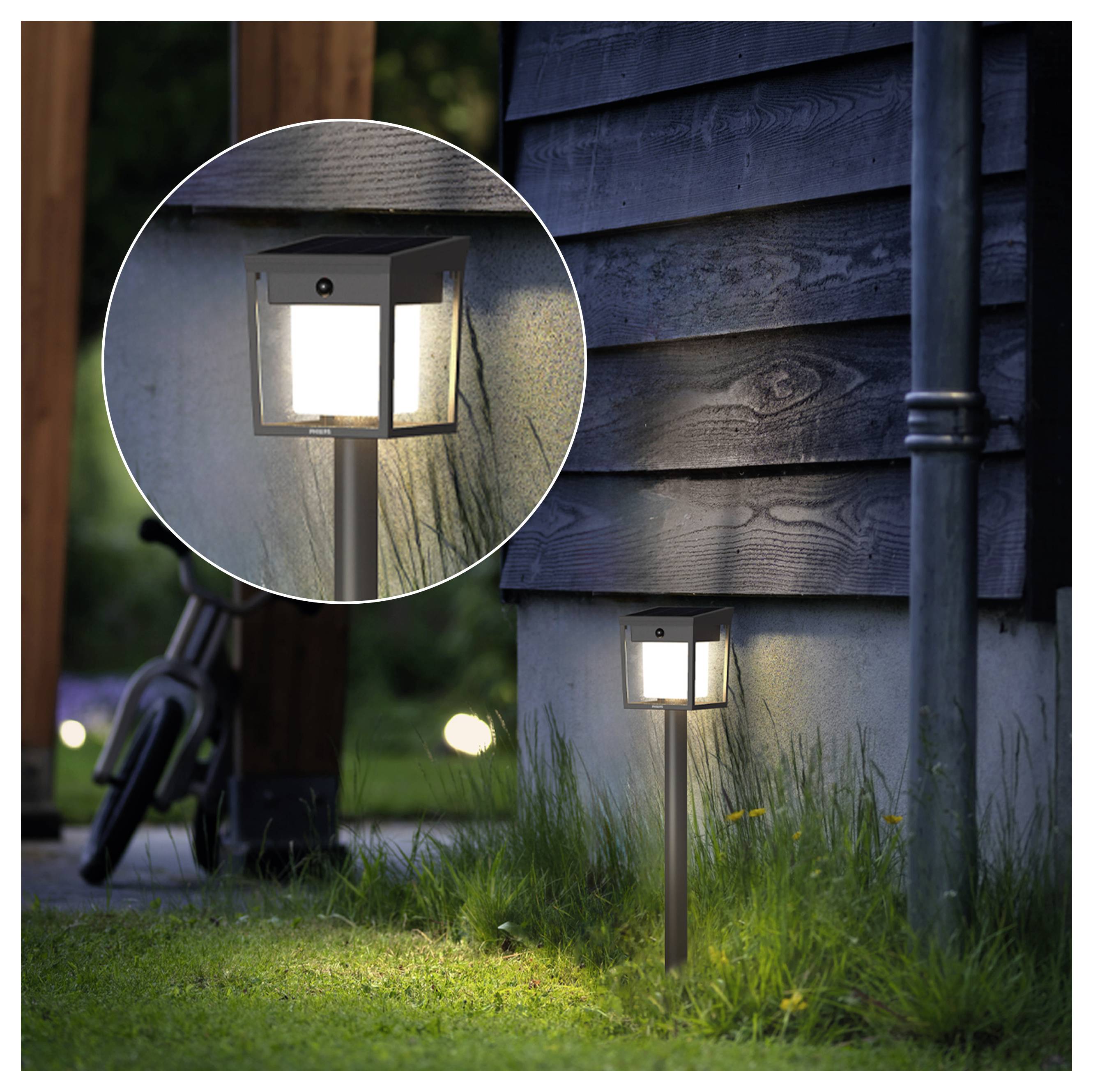 Außenpfadleuchte auf einem Pfahl neben einer Hauswand montiert, beleuchtet in der Dämmerung gezeigt, mit einer zirkulären Detailaufnahme der Lampe.