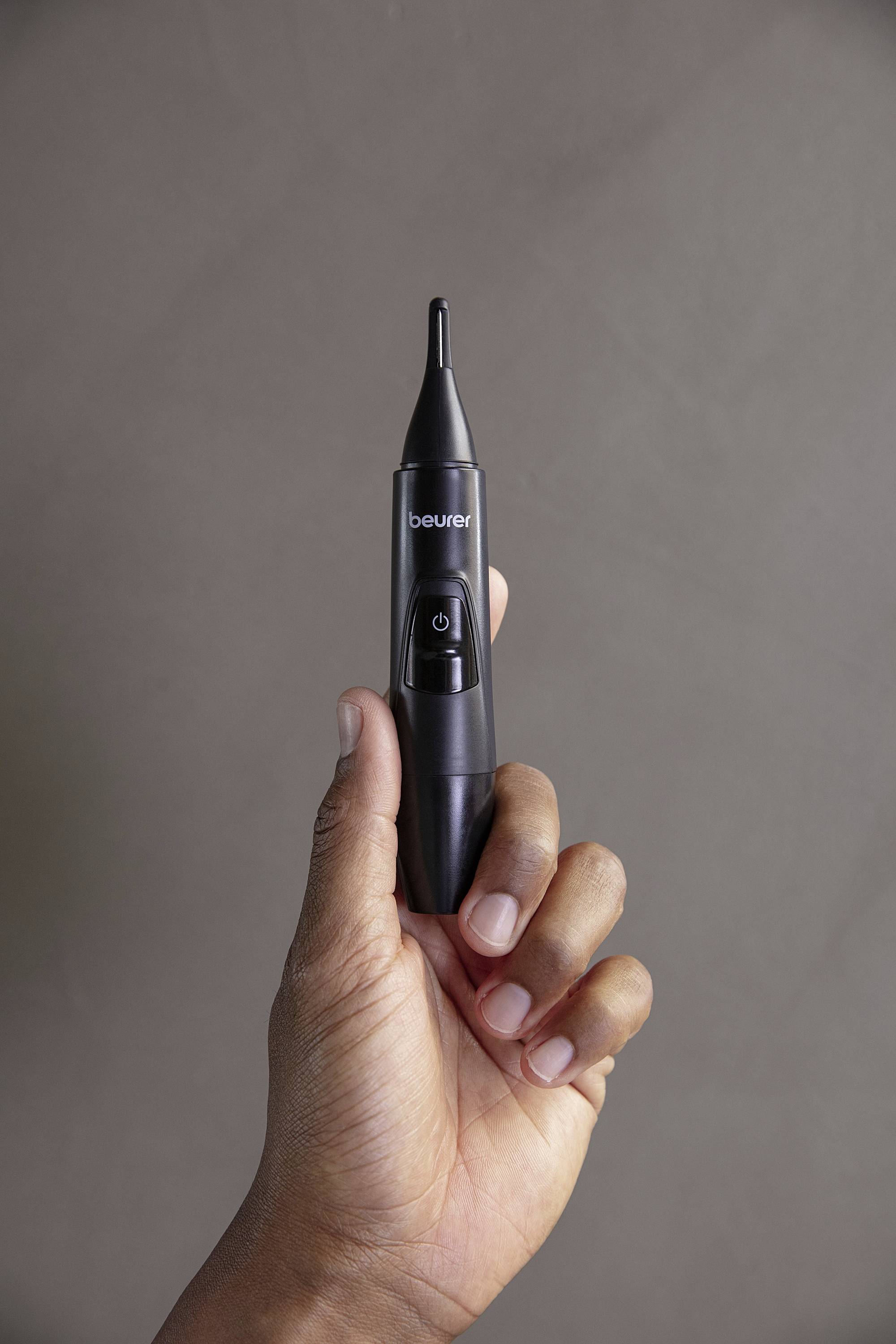 Eine Hand hält ein schwarzes Ohrthermometer.