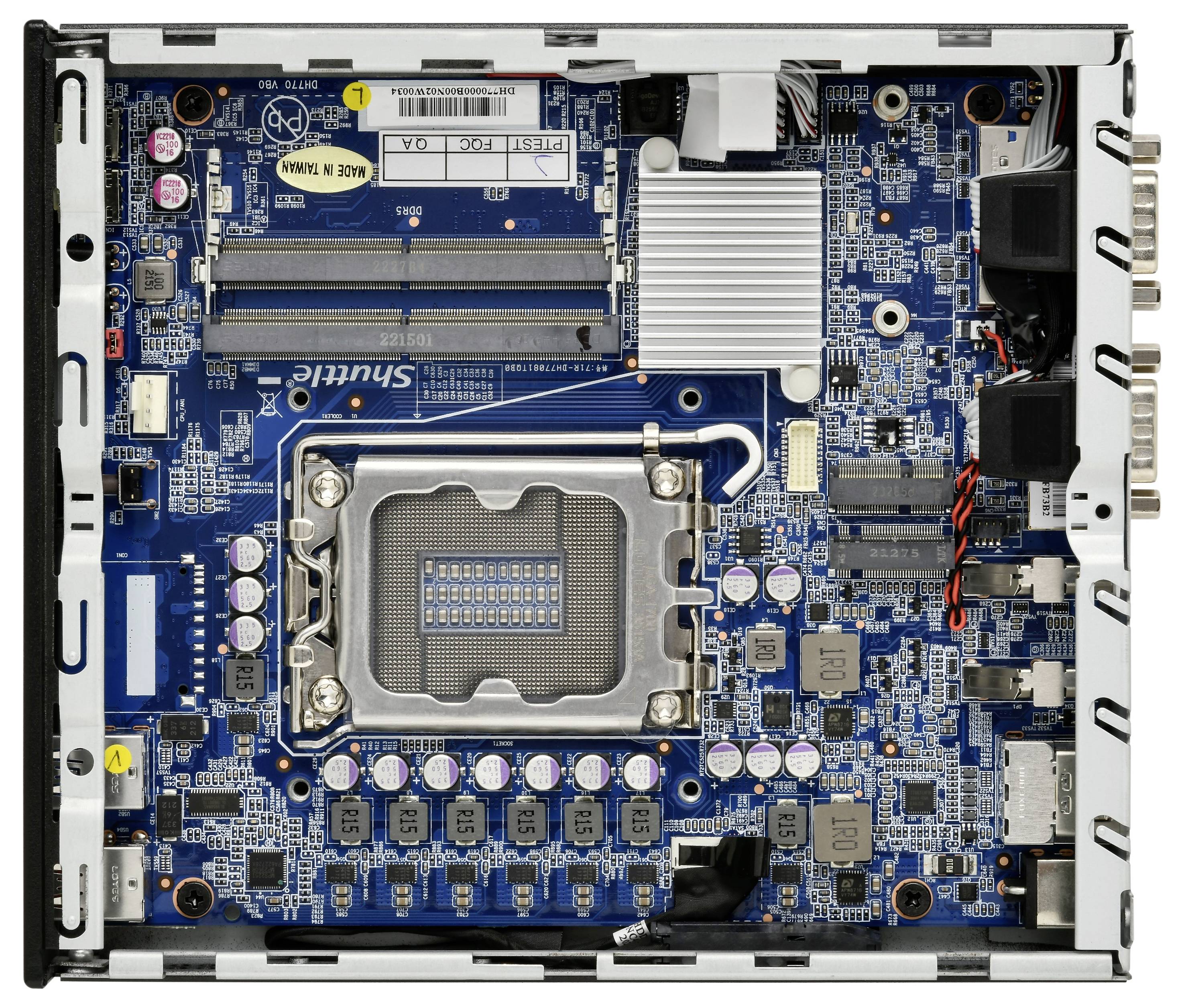 Ein offenes Motherboard mit mehreren elektronischen Komponenten, wie Kondensatoren und Steckverbindungen, sichtbar auf einer blauen Platine.