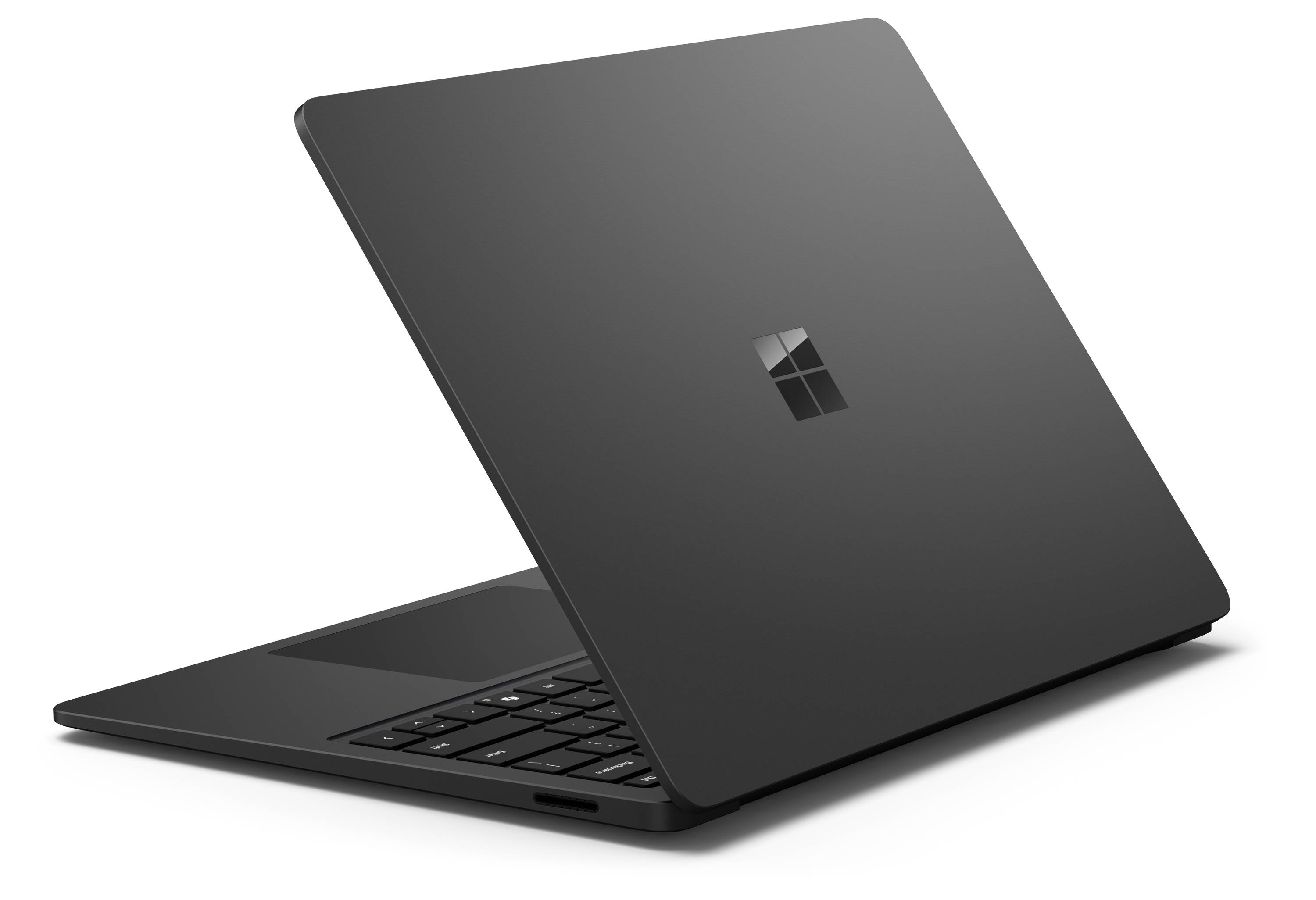 Ein schwarzer Laptop von der Seite mit einem sichtbar glänzenden Fenster-Logo auf dem Deckel. Er ist leicht aufgestellt und zeigt die Tastatur.