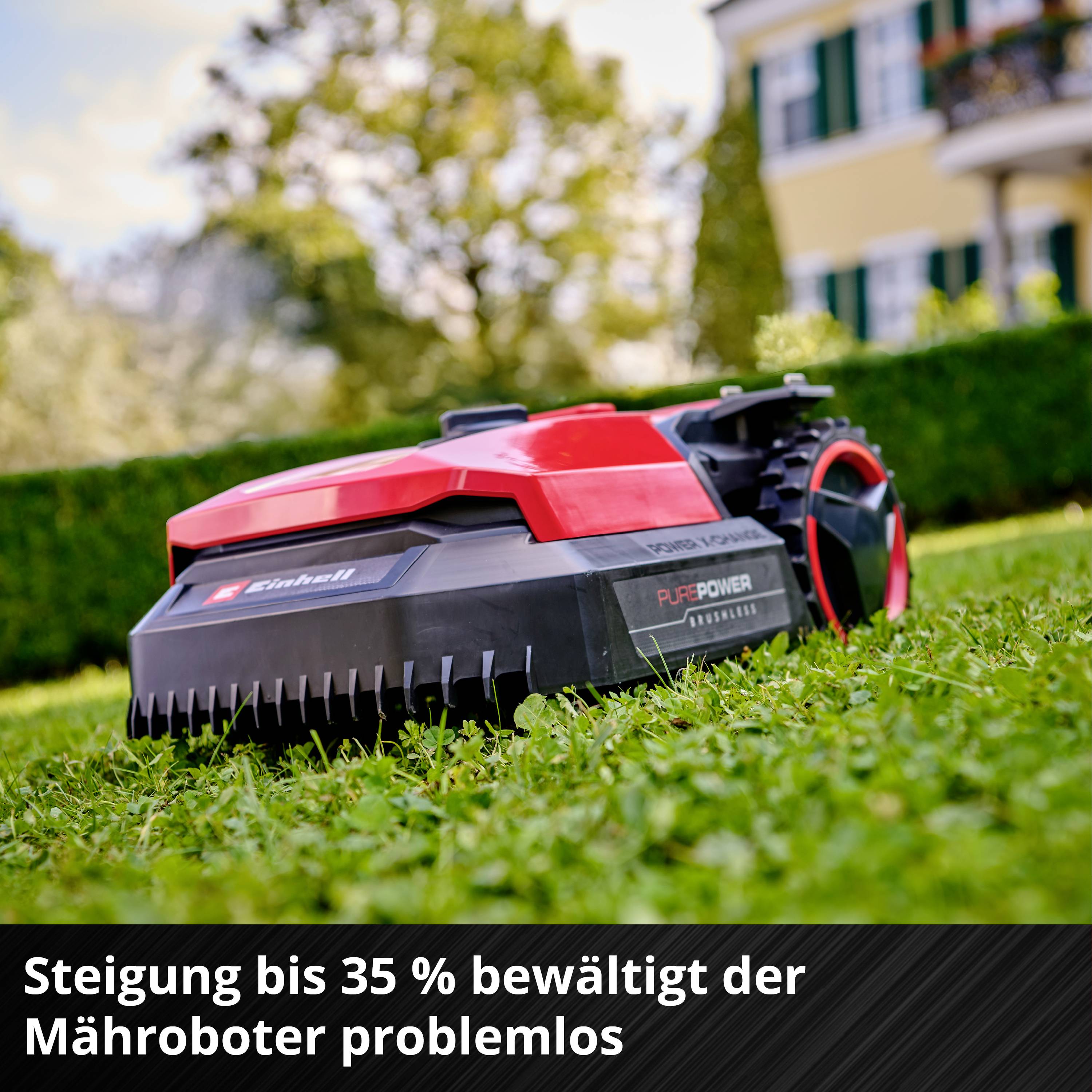 'Ein Mähroboter mäht Rasen vor einem Haus. Text: 