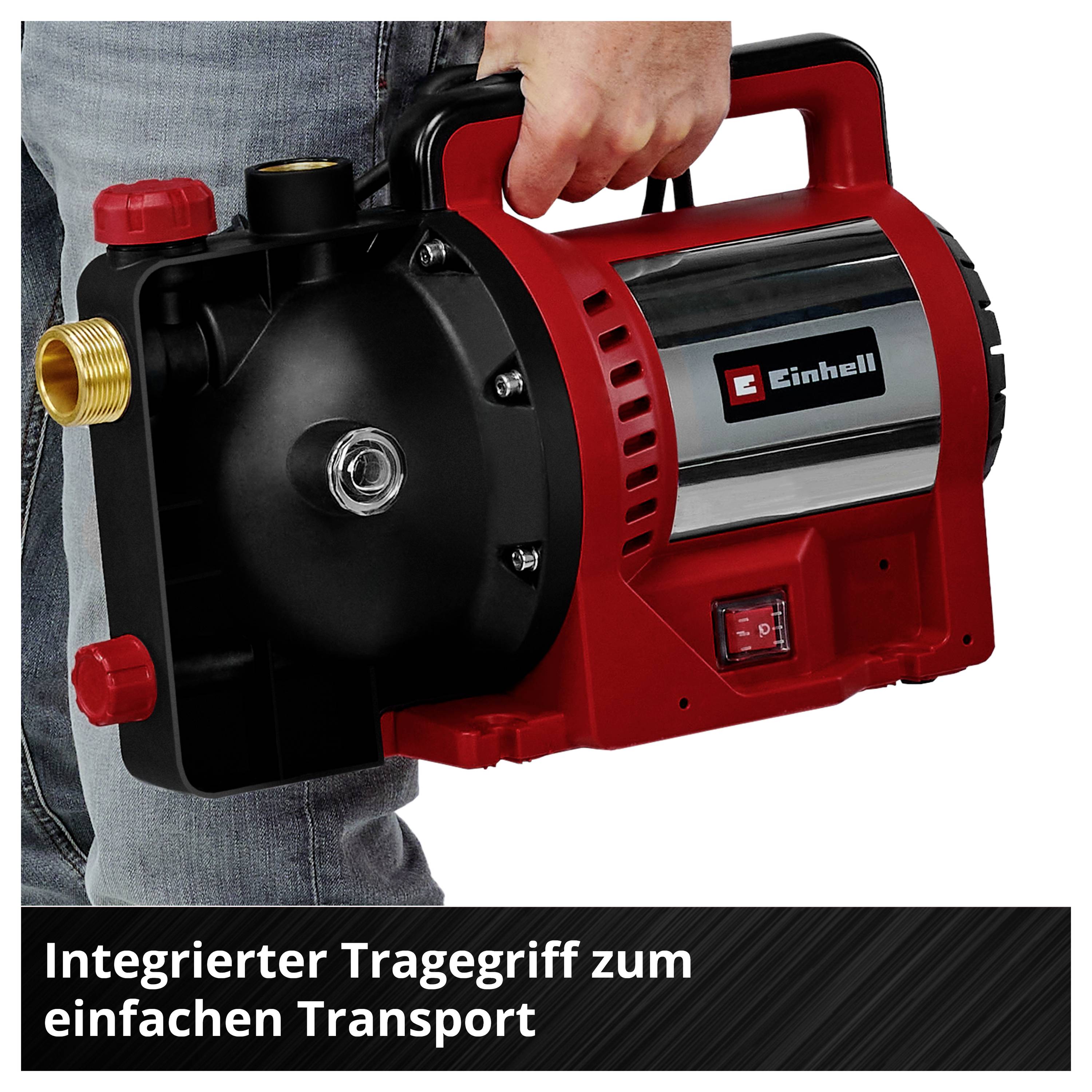 Eine Person trägt eine rote Einhell-Pumpe am integrierten Griff; unten steht 'Integrierter Tragegriff zum einfachen Transport'.