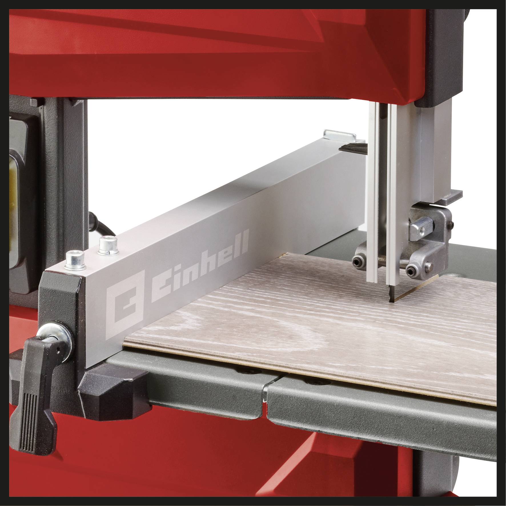 Eine Bandsäge schneidet präzise durch ein Holzbrett. Die Maschine ist teilweise rot und hat das Logo 'Einhell'.