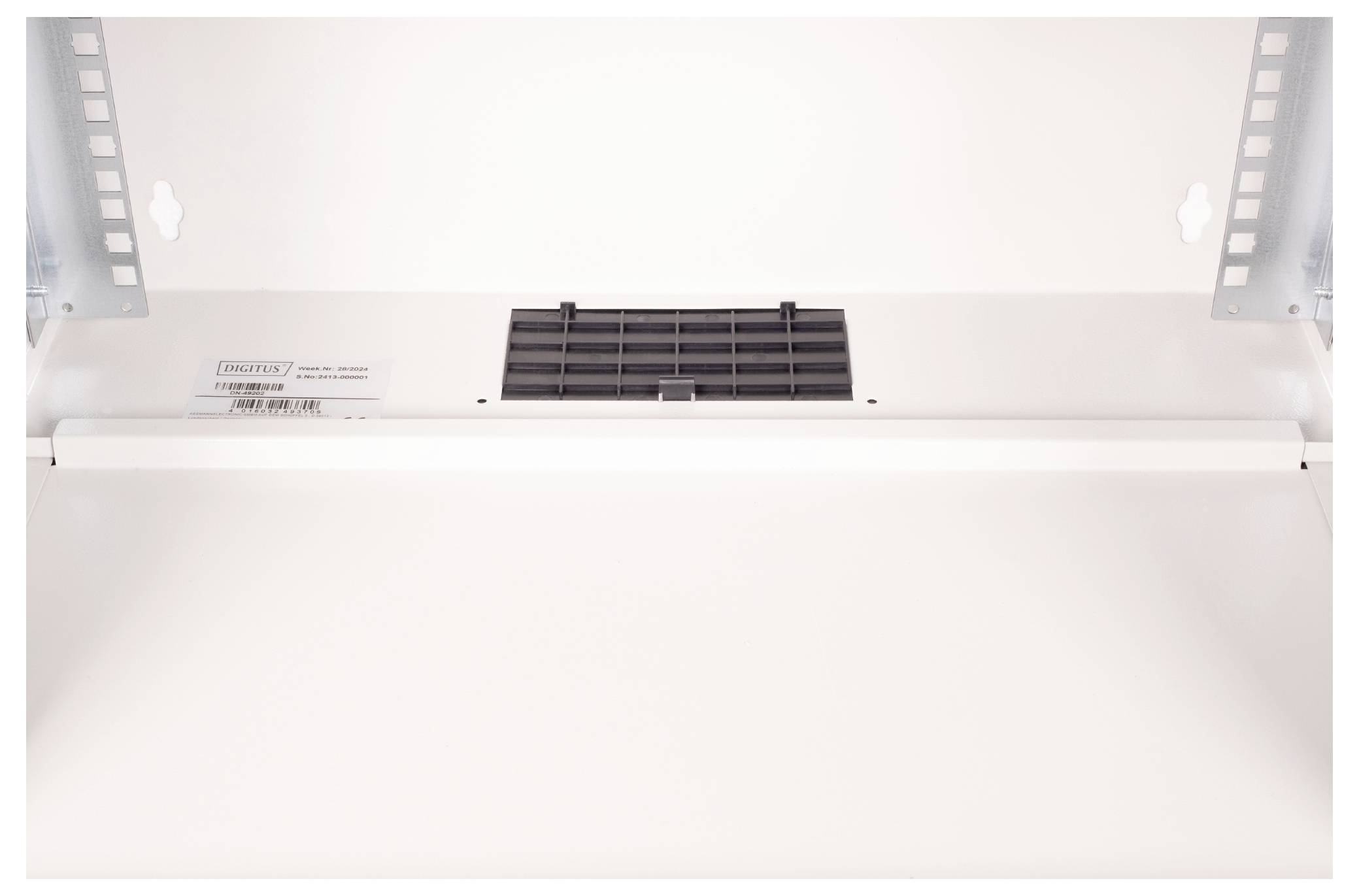 Ein Nahaufnahmebild der Decke eines Indesit-Backofens, das eine Belüftungsöffnung und eine Beleuchtungsvorrichtung zeigt, die Belüftung und Beleuchtung sicherstellt.