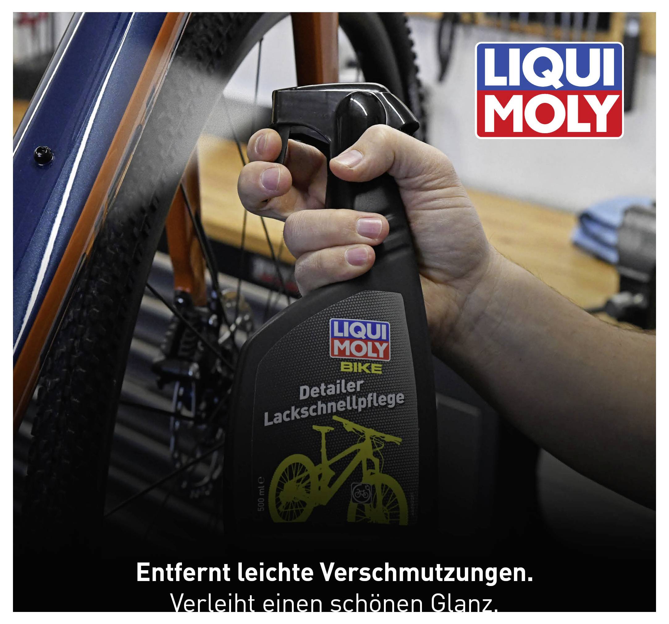 Eine Hand hält eine Flasche Motorrad-Reiniger von Liqui Moly vor einem Fahrrad. Text auf Flasche: 'Entfernt leichte Verschmutzungen. Verleiht einen schönen Glanz.'