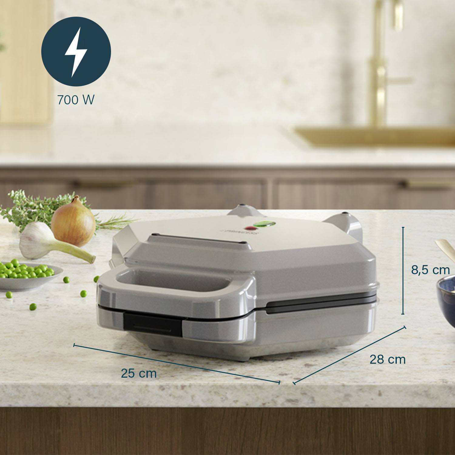 Ein silberner Sandwichmaker mit den Maßen 25 cm x 28 cm x 8,5 cm steht auf einer Küchenarbeitsplatte. Leistung: 700 W.