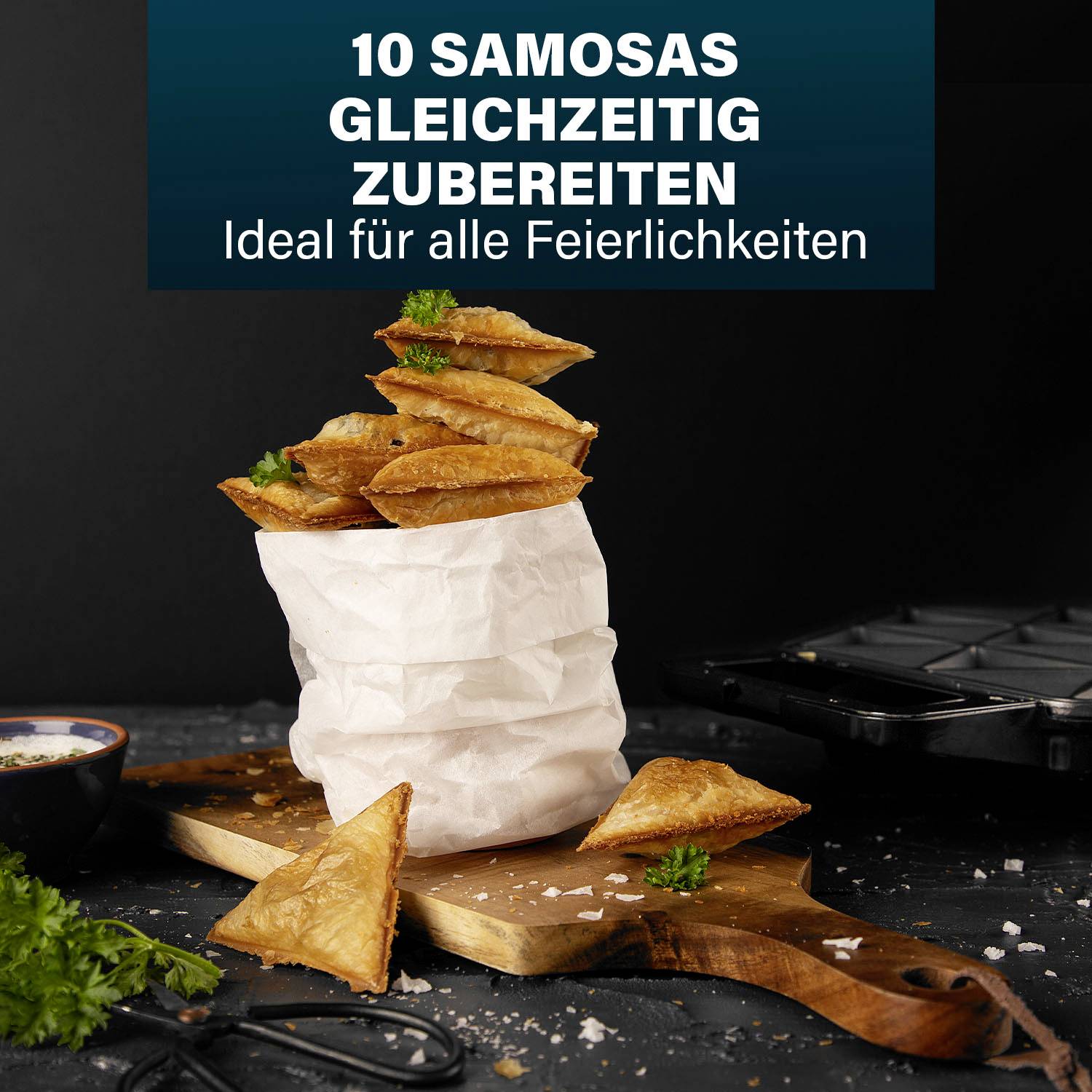 '10 Samosas gleichzeitig zubereiten. Ideal für alle Feierlichkeiten.' Samosas auf einem Holzbrett, mit frischen Kräutern garniert.