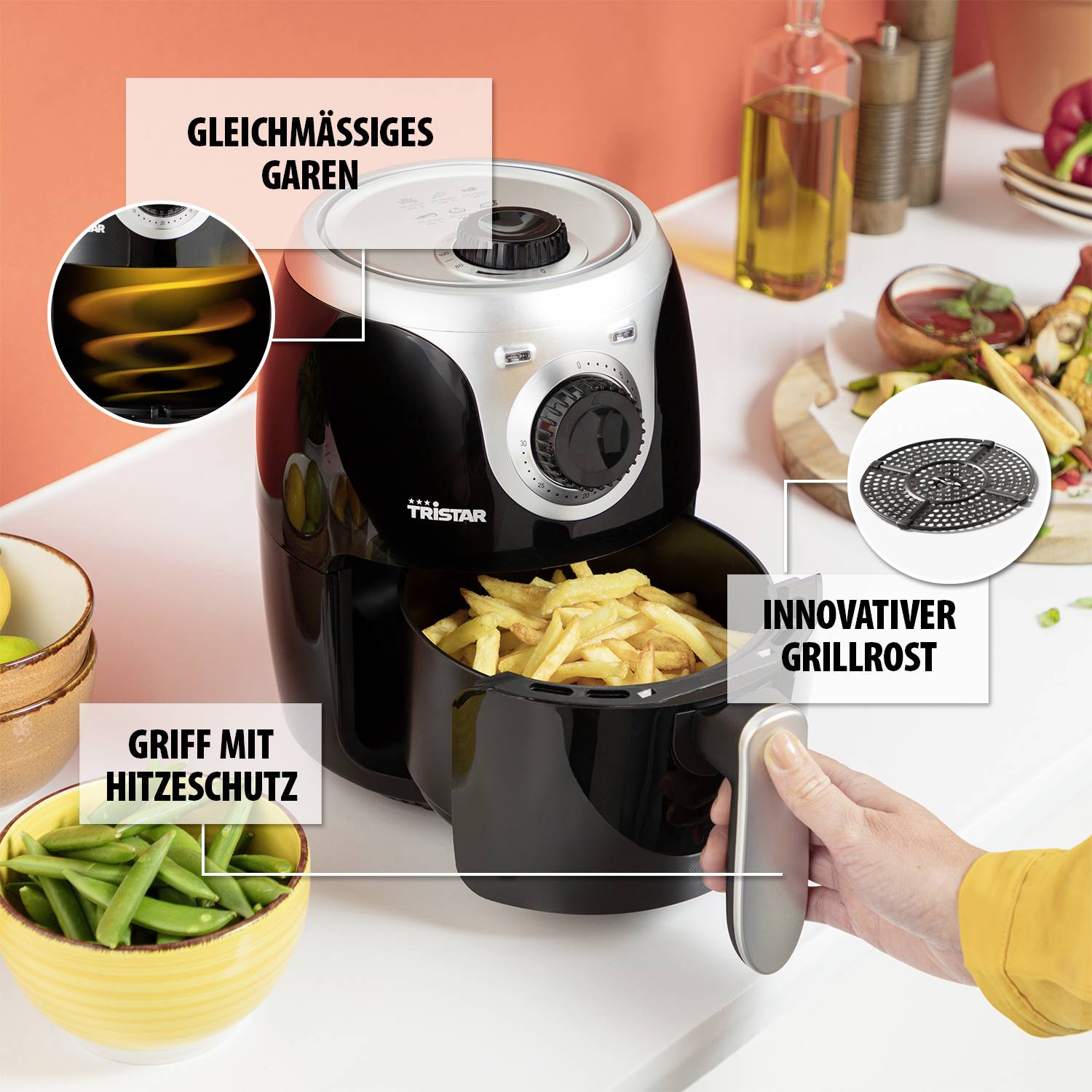 Eine Person entnimmt Pommes frites aus einer Fritteuse. Beschriftungen heben Features hervor: 'Gleichmäßiges Garen', 'Innovativer Grillrost', 'Griff mit Hitzeschutz'.