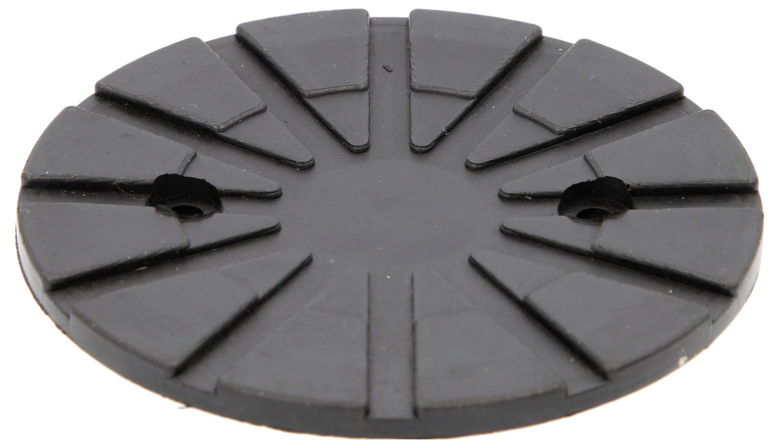 Eine schwarze runde Gummischeibe mit radialen Erhebungen und zwei kleinen Löchern nahe der Mitte.