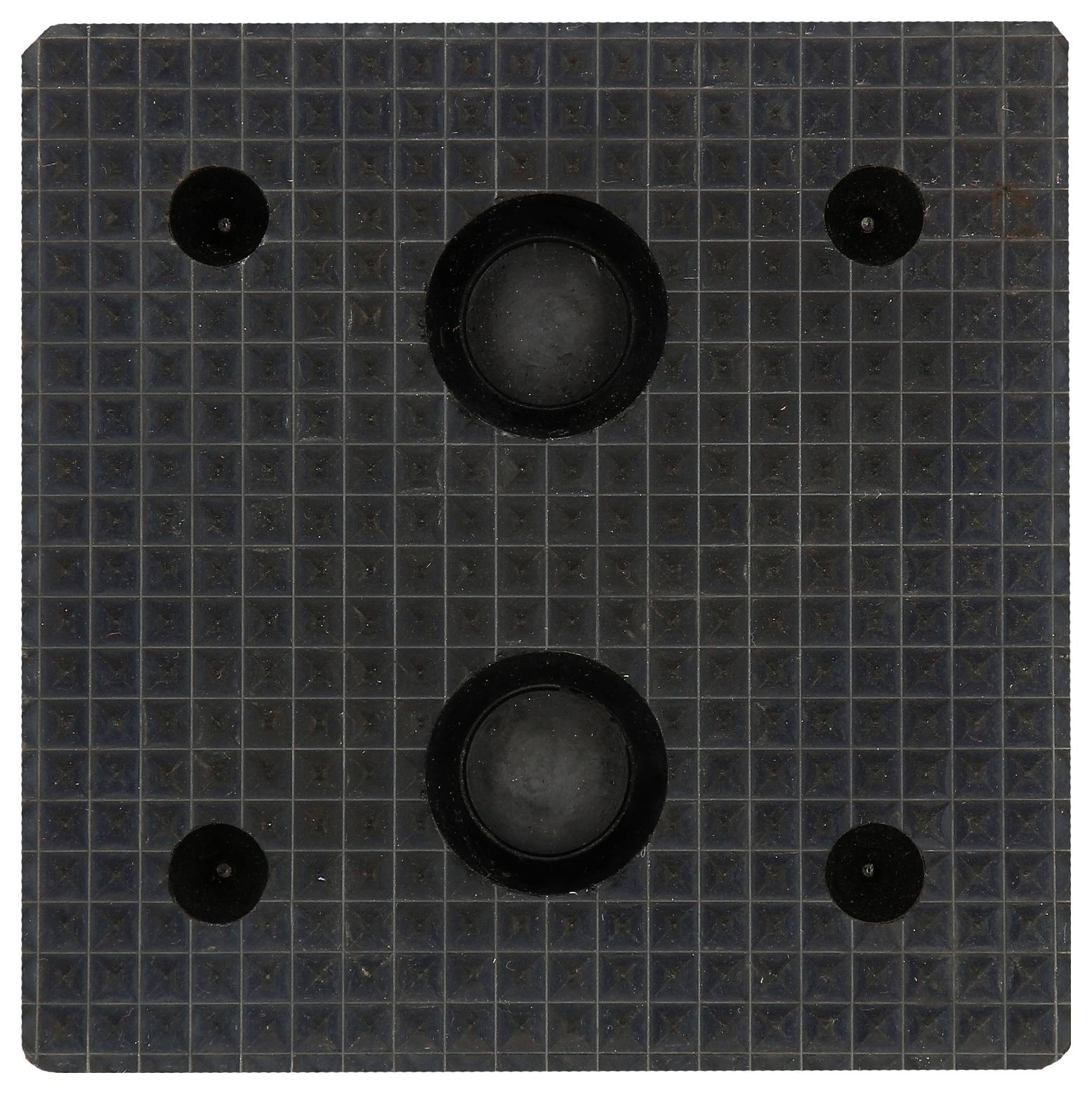 Ein schwarzes Quadrat mit zwei größeren schwarzen Kreisen in der Mitte und vier kleineren Kreisen in den Ecken auf einer karierten Oberfläche.
