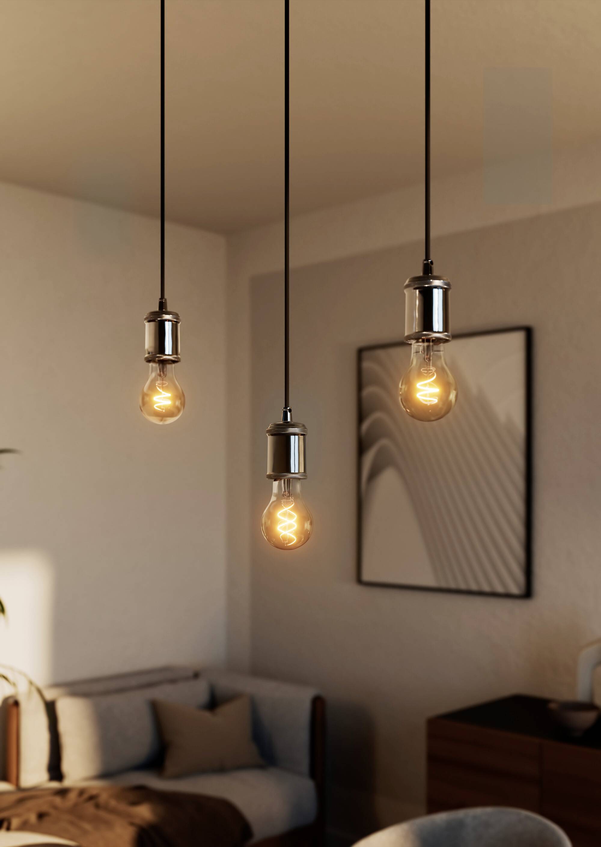 Drei hängende Glühbirnen beleuchten ein modernes Wohnzimmer mit Holzmöbeln und abstraktem Kunstwerk an der Wand.