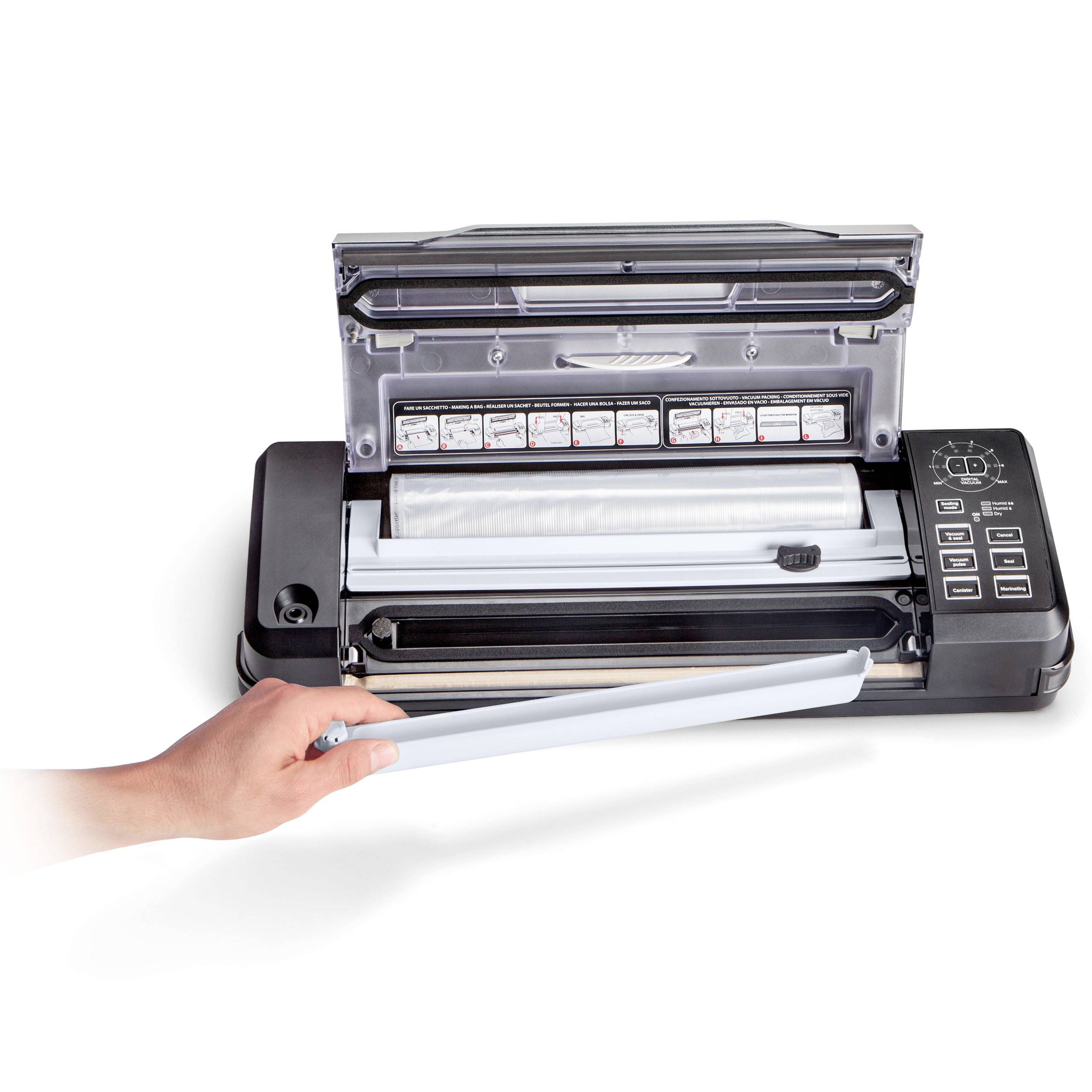 Eine Hand hält eine geöffnete Vakuumiermaschine, bei der die Versiegelungsfläche sichtbar ist. Tastatur und Funktionstasten rechts.