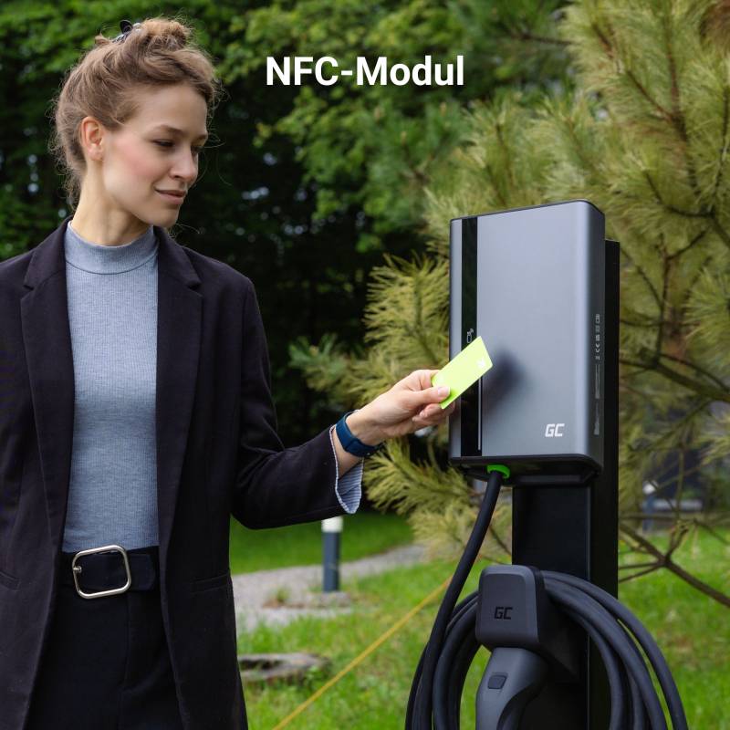 Eine Frau hält eine Karte an ein NFC-Modul einer Ladestation. Im Hintergrund sind Bäume sichtbar.