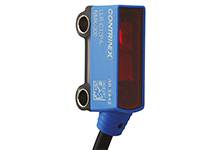 Blauer optischer Sensor mit roter Linse und zwei Befestigungslöchern oben. Markierung: 'CONTRINEX LLR-12PA-3400-309'.